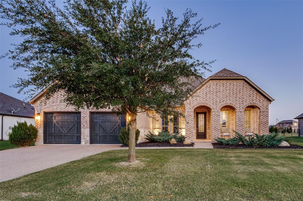 Welcome to 1116 Karsten Ridge Pass, where refined design meets relaxed Texas living in the prestigious Bridges golf community & Gunter ISD. Located on a half-acre lot, this exceptional 1.5-story residence combines striking architecture, upscale finishes & modern design. As you enter, the iron front door opens to rich hardwood flooring, abundant natural light & a private office with French doors & designer accent wall that creates the perfect work-from-home retreat. The open concept main living area is centered around a handcrafted cast-stone fireplace & a dramatic wall of windows overlooking the backyard with convenient electric shades. The completely reimagined kitchen is both sophisticated & functional, featuring granite countertops & backsplash, classic white shaker cabinetry paired with a bold black island quartzite island top, designer lighting, modern hardware & a stunning dining chandelier that creates an elevated aesthetic. Enjoy outdoor dining in the private courtyard, highlighted by a stylish horizontal wood screen wall & direct access from the dining room. The private primary suite is tucked quietly at the back of the home & offers peaceful backyard views & the spa-inspired bath includes dual vanities, a jetted soaking tub & an oversized walk-in shower while the custom-designed closet feels like a boutique with mirrored shelving, dedicated shoe storage & an elegant chandelier. 3 additional bedrooms are conveniently located on the main level with 2 additional baths. Hardwood flooring leads upstairs to a spacious game room with shiplap accents, wet bar, bonus room & full bath—providing flexibility for a media room, guest retreat, or optional 5th bedroom. The backyard is designed for relaxation with iron fencing, a large covered patio, and thoughtfully placed landscaping for added privacy. Residents enjoy resort-style living with access to the renowned Fred Couples designed golf course, community pool, fitness center, clubhouse, tennis courts & more.