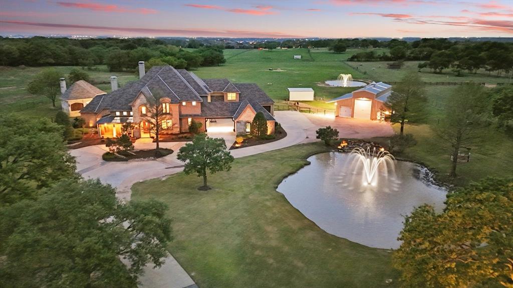 Peaceful Perfection! Welcoming Luxury Estate in the center of Flower Mound LOADED WITH UPDATES! A rare opportunity to own this move in ready estate on 8.35 acres! Wind peacefully on Scenic Drive and enter through the electric gate into this desirable New Haven custom built home. Gorgeous entry with soaring ceiling & designer entry lighting welcomes you home. Large office with gorgeous front views and French doors. Comfortable, livable floor plan offers new carpet, updated colors throughout, hand scraped wood floors, recently updated open chef's kitchen w.Fisher&Paykel gas range, built in refrigerator, large island & timeless brick arches accenting the oversized family room with gorgeous wood beams & beautiful backyard views. Exquisite wine cellar&butlers pantry convenient to kitchen & dining room! Luxury Primary suite on main level offers designer touches in the recently updated large ensuite, two large walk in closets, dual vanities, bath, steam shower, & see through fireplace. Ideal multigenerational home with a 2nd  bedroom & full updated bathroom on main level with own private hallway. Upstairs offers 3 bedrooms, 2 bathrooms, large media room living space and game room with outdoor patio balcony overlooking pool. Upstairs 5th bedroom, or flex room, is currently used as home gym.Resort style backyard includes large pool & spa with lazy river & outdoor speaker system.Pool replastered w.pebbletec last year. 900 SF Cabana offers full outdoor kitchen, large living area with 70 inchTV & heaters.Custom metal barn w. finished floor, RV hookups, 14 foot  high door, drive thru doors, wash drains & more! Fence surrounds 7 acre pasture. Private 875' deep water well to fill ponds & use for sprinkler system! 2 Pond tanks in back pasture & front with fountain. 6 car garage featuring porte cochere. Close to Lake Grapevine & hiking, biking trails. Minutes from exemplary schools. Horses & donkeys available to convey with property. Ag exemption currently in place. New HVAC units.