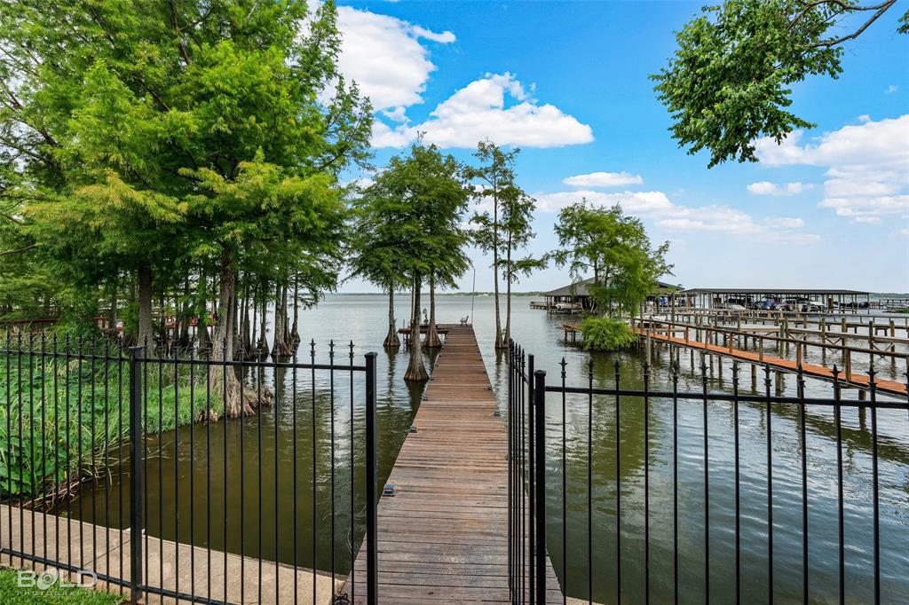 Lakefront property located in the gated community of Willow Ridge directly on Cross Lake. This home offers an open floor plan with tall ceilings, a large kitchen with double islands, and living and dining areas oriented toward the water. The layout includes two primary bedrooms one on each level and multiple spaces designed to capture lake views throughout the home.

Outdoor features include large screened-in porches on both the main level as well as the upper level, a fenced backyard, manicured landscaping, and a private pier and deck accessible from the property. The community provides access to a pool, tennis courts, pickleball courts, and a clubhouse. The neighborhood boat dock is located only moments from the property. Marina boat slip is reserved for the new buyer. New roof installed in 2023.