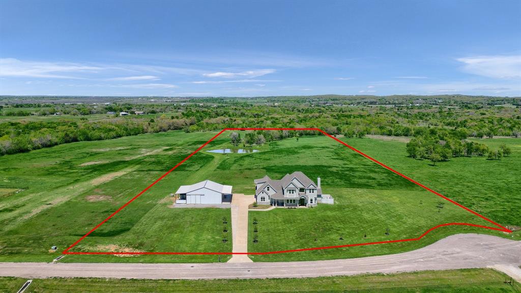 This custom home situated beautifully on 11 acres features peaceful country living, yet is close to shopping, restaurants, medical care, & Lake Texoma. Beautiful views of nature abound from every window. Highlights include granite counters throughout, double ovens, gas cooktop & pot filler with easy access cabinets. December 2025 updates: new roof and gutters, exterior paint plus stained and sealed decking. Full apartment (mother-in-law suite) features large bedroom, full kitchen, living area & bath, with 2 separate entrances. Stunning backyard oasis with a large travertine patio, low maintenance artificial turf, hot tub & pool that features swim jets, a large shallow play-lounge area. The spacious primary suite with spa-like bath, fireplace, & private deck with 180-degree views assures a perfect retreat for R&R.  Additional updates since 2020: 36x40 workshop, pond, backyard oasis, all landscaping, new & improved cabinetry & storage, & MIL suite AC unit. Ten acres are AG exempt. Call for more details.