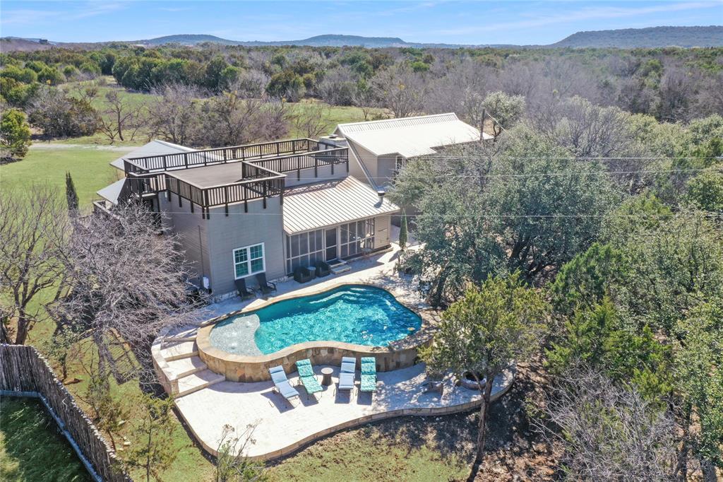 CHARMING, FURNISHED, HISTORIC 3157 SQFT, 5BD, 3BA LAKEHOUSE on the WESTSIDE of PK WITH GUESTHOUSE, POOL, SCREENED IN PORCH, & 4 CAR GARAGE, on .74 acres, Perfect for Entertaining Friends and Family, with a Beautiful PK Lake View, from the Pool and the Upper View Deck. The house is surrounded by Mature Shade Trees and has a Big Grassy Yard for Yard Games as well. Inside the House features a Gourmet Kitchen with Stainless Appliances with a Commercial Refrigerator, Double Ovens, Granite Counters, and Wood Floors throughout the house, a Dining Room and Bar area with 2 Dining Room Tables for extra guests, a Sitting and Game Table Nook, a Primary Suite Bedroom & Bath, and 2 Large Guest Rooms with an additional Bath. a Spacious Vaulted Living Room with Rock Fireplace that has a patio Door that opens up to the Screened in Porch also with a Cozy Fireplace, and Pool, Outside Dining, Seating & BBQ Areas, to Relax and Recharge, and Savor the Serenity & Beauty of PK. Then above the 4 Car Garage, there is a Guesthouse with Full Living and Game Room area with a Pool Table, 2 more Guest Bedrooms and another Bath. The Prior Owners used it as a very popular Overnight Rental, so it is Ideal for that. The Lake House is also located close to 2 great Westside Restaurants, and the Breakers Marina is nearby to keep a Boat on the water, plus the House is is only a 15 minute drive to the Lovely Town of Graham for Amenities, Shopping and more Dining Options as well. This Wonderful Lakehouse offers an Amazing Affordable Way to be at PK, and Overnight Rent the House as an Investment or to Offset Expenses. Priced to Sell & Turn Key Ready to Enjoy the Best of PK LakeLife.