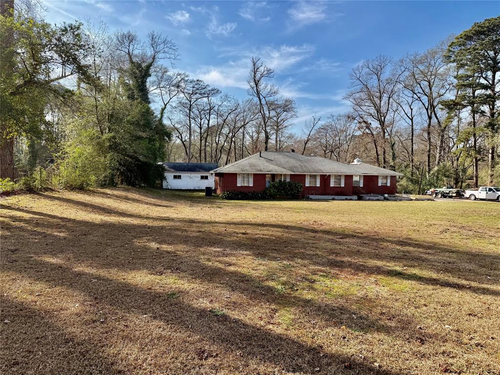 **Spacious 3BR Home on 5.14 Acres with Bonus Room, Fireplace, Covered Patio & Oversized Garage**

Set on approximately 5.14 acres in North Shreveport, this spacious 3-bedroom, 2-bath home offers 2,850 square feet of classic comfort, generous living areas, and exceptional storage throughout. A traditional layout combined with timeless details makes this property ideal for those seeking space, privacy, and versatility.

Interior features include wood flooring, crown molding, a formal living room, and a formal dining room accented by a beautiful chandelier—perfect for entertaining. The inviting den includes a wood-burning fireplace and provides a cozy everyday living space. The spacious kitchen offers built-in appliances, ample cabinetry, and a pantry, with convenient access to the inside laundry room complete with washer, dryer (not warrantied), and broom closet.

The primary bedroom serves as a private retreat with a large walk-in closet featuring built-in dresser drawers and storage. The ensuite bath includes a stall shower with a bench. All three bedrooms are generously sized, offering flexibility for occupants, guests, or home office needs.

A bonus room filled with built-in bookcases adds valuable extra living space and is complemented by a separate storage room with built-in cabinets and workspace. Additional highlights include an oversized garage with multiple storage areas, a covered patio, established herb gardens, a private well, and expansive outdoor space with endless potential.

This property offers a rare combination of acreage, square footage, and classic features with room to personalize. Located along North Market Street in North Shreveport, this area is known for larger acreage properties, a quiet country-style setting, and fewer restrictions. Enjoy easy access to I-49 and a convenient commute to downtown Shreveport while still having space, privacy, and flexibility. Sold As Is.