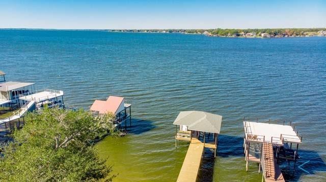 Come see this wonderfully unique luxury Waterfront home located on DEEP water at Cedar Creek Lake.  Situated on a Peaceful cul-de-sac street this 5 bedroom 4 bath home is nestled beneath towering oaks on beautifully landscaped site.  The many sterling qualities of this home include handsome and enduring stucco façade, sprawling great room with wood burning fireplace, expansive windows, banquet sized dining area, split bedroom design, low maintenance Saltillo flooring, luxurious lakeside primary bedroom and ensuite bath, and many additional features throughout.  The kitchen will delight the most accomplished chef with its double self cleaning ovens, range top, custom cabinetry, dining island, and sheer size and versatility.  BONUS ROOM or multi-function office game room with second fireplace.  Outside features include spacious screened-in porch for added privacy, upper & lower decks, landscaping, towering trees & breathtaking water views.  Impressive boathouse with PWC lift.