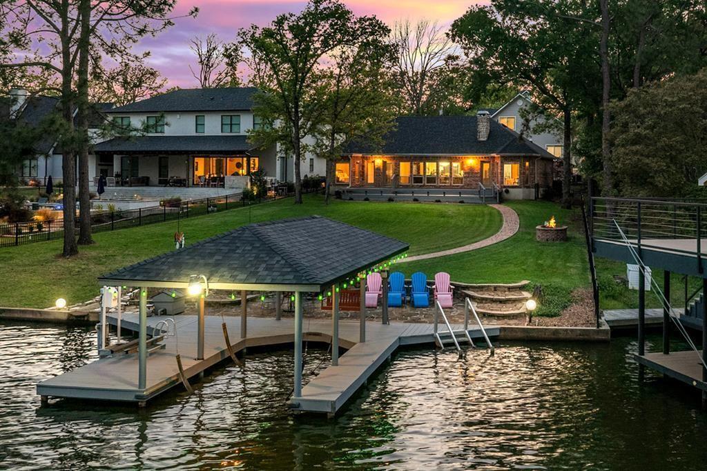 This exquisite Lake House presents a main residence with a striking WOW factor, complemented by a guest suite for additional accommodation and an expansive bonus-game-family room. Situated just off the shores of Cedar Creek Lake, this waterfront property seamlessly blends serene natural beauty with modern amenities in a highly desirable location. Free from HOA fees, you can enjoy your morning coffee on the back porch while taking in the breathtaking views or stroll along the stone path through mature trees to your private dock, which offers over 89 feet of waterfrontage. The home is adorned with solid cedar beams, scored concrete floors, granite countertops, and custom cabinetry. A wall of windows and a magnificent stone fireplace provide panoramic lake views, making this home perfect for entertaining. The open floor plan includes three bedrooms and two and a half bathrooms in the main house, complemented by a guest suite that can accommodate two additional bedrooms, a full bathroom, and a versatile bonus room—offering a total of over 3,054 square feet of living space, ideal for a lakeside retreat. Additional amenities include a spacious garage with a workshop area and a generator transfer switch. Recent updates in 2024 feature a new roof, HVAC system, fresh paint, new carpet, and a remodeled primary bathroom. The foundation is reinforced with 12-foot deep pilings, with specifications available on-site. Enjoy sunset views from the back porch and take advantage of the boat house equipped with a power lift for your boat and jet skis. The home is ideally positioned just off open water in a protected cove, perfect for swimming and kayaking. The property also boasts meticulously maintained landscaping and a lake pump. Seize this opportunity for the ultimate lakeside escape, located in one of the most coveted areas on Cedar Creek Lake. The house SF of 3054 is divided into two homes, the main home 1806 SF with a Guest house of 1248 SF.