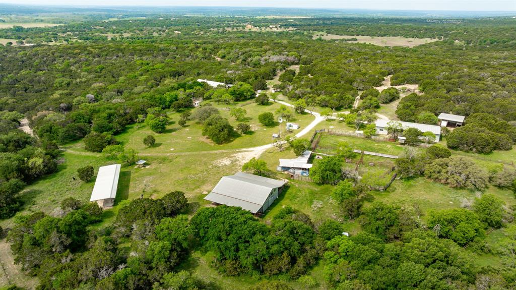 This 400-acre property in Hamilton County offers a unique opportunity for investment, recreation, or residential use in the heart of Hamilton, Texas. Formerly a working bison ranch, it carries both character and legacy. Located just 13 miles from Hico and Hamilton, the property is easily accessible to dining, shopping, and medical services. 

The main entrance, with custom stone gates, leads to a distinctive stucco lodge designed for entertaining. The lodge features a massive great room, vaulted ceilings, an open kitchen and dining area, a loft with a full bath, a primary suite with a kitchenette and a private entrance, plus a guest room and laundry. Downstairs offers another large kitchen and suite, full bath, and half bath, ideal for gatherings or family retreats.

Outside, improvements include a large metal workshop, cattle pens, barns, and an original windmill. The scenic terrain features rolling land, hardwoods, and a stock tank for livestock and wildlife. A separate entrance off CR 105 leads to an area featuring large oaks, a water well, an RV hookup, and electricity, ideal for a future homesite or weekend getaway.

With versatile improvements, extensive road frontage, and infrastructure, this property is well-suited for a hunting lodge, family compound, or long-term investment.