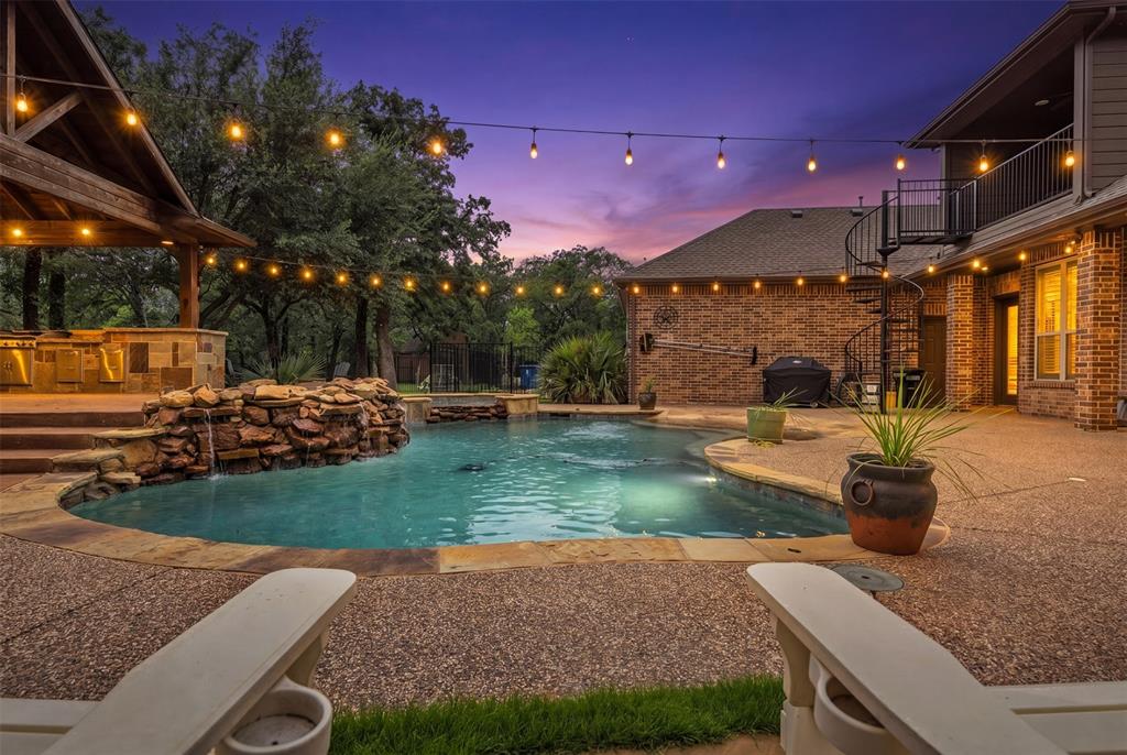Nestled on a beautifully treed estate lot in the prestigious town of Double Oak in the Taylor Oaks subdivision, this exceptional custom home offers the perfect blend of luxury, privacy, and resort-style living. From the moment you arrive through the gated entrance and expansive circular drive, you'll be captivated by the home's timeless architecture, mature oak trees, and impressive curb appeal.

Inside, soaring ceilings, rich hardwood floors, extensive custom millwork, and a stunning floor-to-ceiling stone fireplace create an inviting atmosphere. The spacious floor plan features 5 bedrooms, 4.5 bathrooms, a dedicated office, formal dining, and generous living spaces designed for both everyday comfort and entertaining. The chef's kitchen is equipped with custom cabinetry, granite countertops, double ovens, a large center island, and abundant storage.

The private primary suite offers a spa-inspired bath, oversized walk-in closet, and direct access to the outdoor living spaces. Upstairs, additional bedrooms, a game room, and a private balcony overlook the backyard retreat.

Step outside to your own backyard paradise featuring a sparkling pool and spa with rock waterfall, expansive patio areas, fire pit, and an incredible outdoor pavilion complete with outdoor kitchen, fireplace, bar seating, and mounted TV—perfect for year-round entertaining. The fully fenced property backs to open green space and is surrounded by towering trees, providing unmatched privacy and serenity. A spacious 3-car garage, gated motor court, and ample parking complete this one-of-a-kind estate.

Experience luxury country living with city conveniences just minutes away at 140 Eagles Peak Lane.