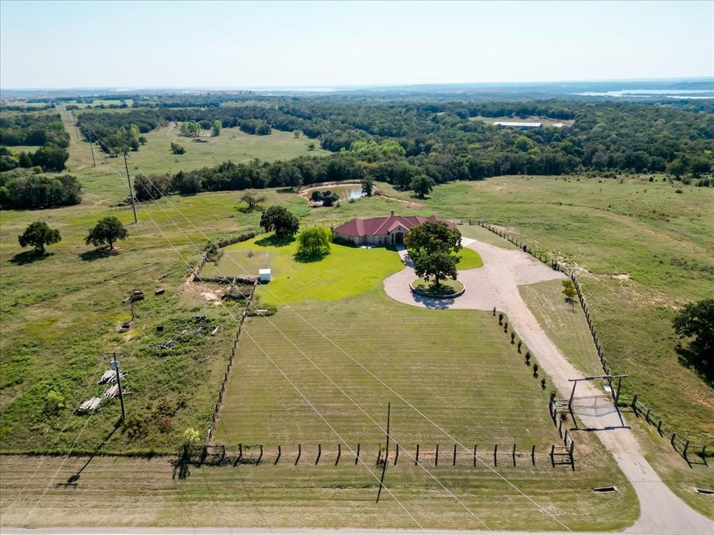 Additional Acreage available add a few acres or check out MLS#21151698.  Where Rustic Charm Meets Modern Luxury, come and take a look! 
Experience timeless Texas elegance at this custom-built ranch estate just outside Chico. Set on a peaceful stretch of FM 1810, this beautifully crafted 2007 built home spans approx. 2,900 sq ft and blends rustic charm with modern luxury.

Inside, warm wood accents and rich tile flooring create a welcoming, upscale feel. The gourmet kitchen features handcrafted cabinetry, granite countertops, and premium appliances—designed for both everyday living and effortless entertaining. A stone fireplace anchors the open-concept living space, framed by large windows that capture wide-open views of the surrounding countryside.

The private primary suite is a retreat of its own, complete with cedar walk-in closets and a spa-like ensuite bath. Each bedroom is generously sized, with custom touches throughout.

Step outside to an expansive covered patio that invites outdoor living, dining, and relaxation—all set against the backdrop of rolling pastureland. Ideal for ranching, recreation, or simply enjoying the serene beauty of North Texas.