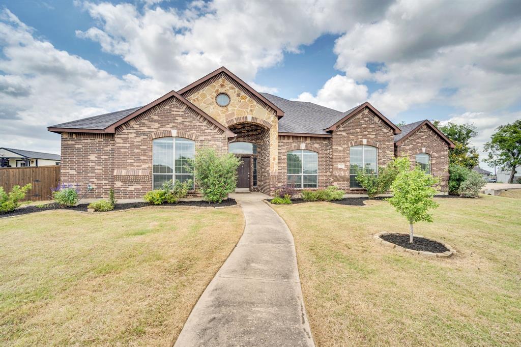 COUNTY TAXES AND NO HOA! CORNER LOT ON OVER HALF AN ACRE! Situated on a little over a half acre corner lot, this meticulously maintained 2,741 sq. ft.home offers 3 bedrooms WITH AN OFFICE! Office has a closet and could also serve as a 4th bedroom. Built in 2014 and recently refreshed with new paint and landscaping! The Sellers fenced in the backyard and removed all carpet when they moved into the home. This home offers warm, natural light throughout. Decorative lighting, durable luxury vinyl plank flooring with tile flooring in the kitchen and bathrooms. Spacious kitchen offers ample space for all your cooking needs with beautiful wood cabinets, a large island, an electric cooktop, a refrigerator, a stainless steel dishwasher, oven, and built-in microwave. The kitchen seamlessly flows into the eat in breakfast nook as well as into the formal dining area. Relax by the wood-burning fireplace on a cold winter night in the cozy living room, or retreat to the  private office for a quiet workspace. The functional split-bedroom layout includes a primary suite, two additional bedrooms, and an office. The sunny laundry room includes a wash sink and an electric dryer. The home internet service is through Starlink and the water system is through the Rocket Special Utility District. Outside, enjoy the freedom of a massive, fenced-in backyard with an extended back patio. There is a plum tree, a peach tree, a pomegranite tree, and plenty of room for chickens to roam! Also plenty of room to add a shop or a pool! Endless possibilities with no HOA! The 3-car garage offers room for all your vehicles or just a place to tinker. Located in the sought-after Waxahachie ISD and just minutes from local shopping, eateries, and entertainment, this property combines small-town charm with everyday convenience. Schedule your showing today! We'd love to show it to you!