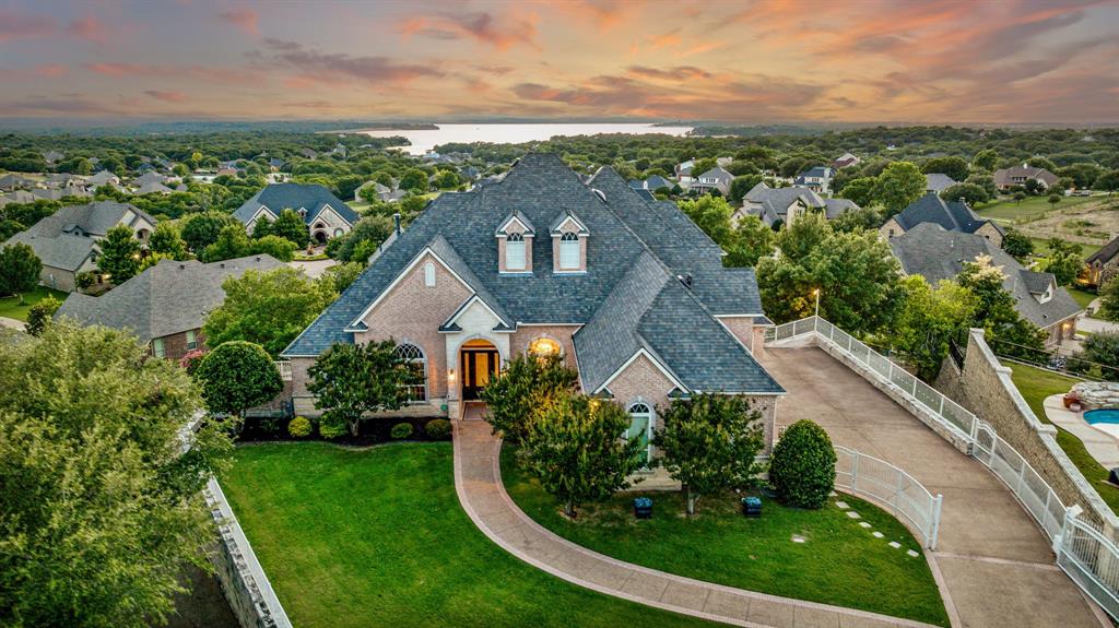 Stunning Three-Story Home with Breathtaking Eagle Mountain Lake Views. Nestled in a quiet cul-de-sac, this exceptional home offers panoramic views of Eagle Mountain Lake and unforgettable sunsets from every level. An oversized elegant resort style pool designed for both relaxation and swimming laps. This residence boasts floor-to-ceiling windows that flood the home with natural light while framing the serene beauty of the lake. The grand staircase serves as a striking architectural centerpiece, leading you through spacious living areas perfect for entertaining or relaxing. Primary suite with beautiful dual vanities. Open kitchen design. An elevator leads you to the game room with its own spectacular view of the pool and lake, ideal for hosting friends or enjoying peaceful evenings at home. Stay fit in your private home gym, then unwind on the patio as the sun dips below the horizon. Whether you’re enjoying a quiet evening or entertaining guests, the setting is nothing short of spectacular. This one-of-a-kind property offers luxury, privacy, and a front-row seat to some of the most beautiful scenery Eagle Mountain has to offer. Schedule your private tour today.