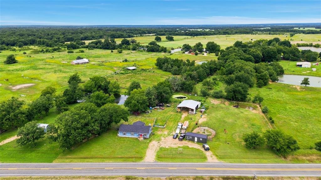 Want to escape the city without disappearing into the wilderness and communicating by carrier pigeon? This might be your spot.
Nestled on 1.5+ acres in Telephone, TX and just minutes from Bois d’Arc Lake, this charming 2 bed, 1 bath home offers the kind of country living people daydream about while sitting in traffic.
Inside, you’ll find an open-concept layout that still feels warm, cozy, and country, complete with a wood-burning fireplace perfect for chilly mornings, hot coffee, and pretending your to-do list doesn’t exist.
Outside is where this property really starts showing off. The fenced acreage features a garden area, two ponds, a pipe-fenced pasture, and a barn with electricity just waiting for horses. There’s also a designated round pen area with patience poles, making this a fantastic setup for horse lovers. In fact, the property has been used by a horse trainer and is thoughtfully laid out with multiple functional gates, pipe fencing along the back and side property lines, and a setup designed to actually work—not just look pretty in photos.
Dreaming of fresh eggs? The chicken coops are already in place. Want a few horses in the backyard? Done. Looking for space to grow a garden, watch the sunset, and hear yourself think? You’ve found it.
Need room for a side hustle? There’s also a bonus shop building, currently used as a T-shirt business, that’s negotiable with an acceptable offer and would make a great workshop, studio, or small business space.
One of the best-kept secrets? Fannin County’s lower property tax rates compared to many surrounding areas, giving you more room in the budget for the things that matter.
And for outdoor enthusiasts, you’re perfectly positioned between adventure and convenience. The property sits roughly 10 minutes in either direction from the LBJ National Grasslands and Caddo National Grasslands, offering thousands of acres of riding trails, hiking, fishing, hunting, camping, and recreation practically in your backyard.