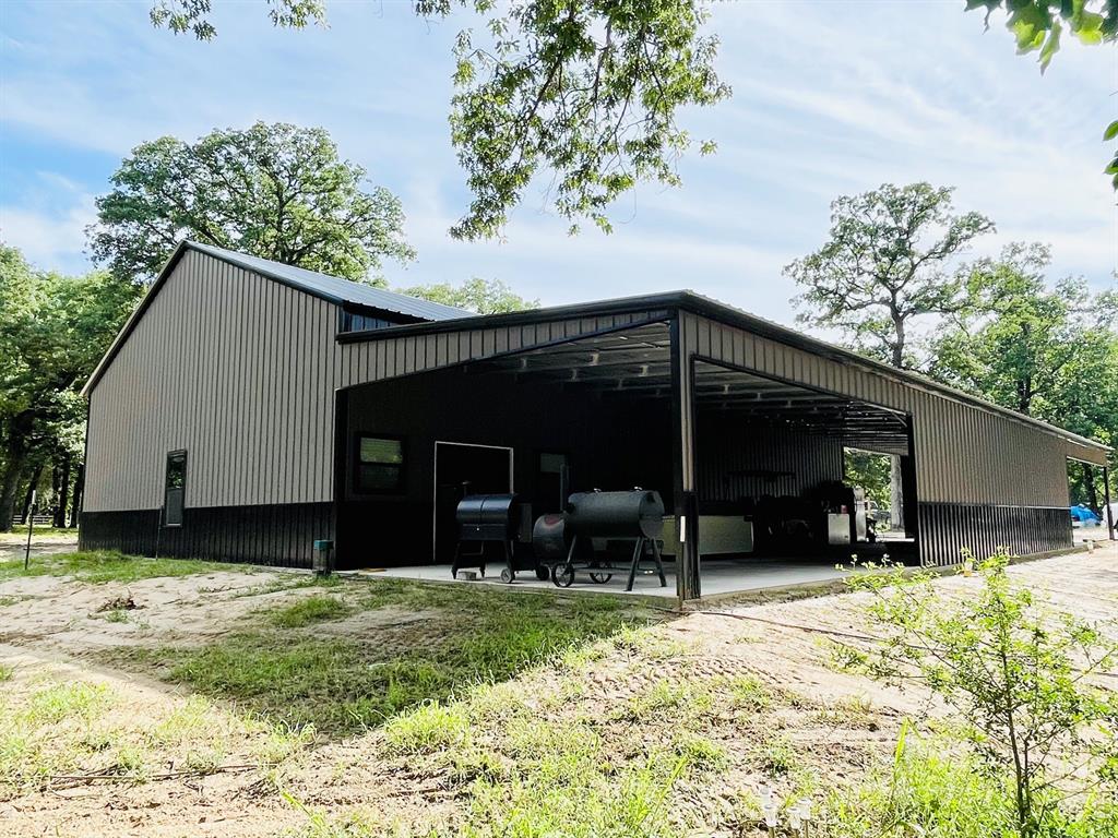 Secluded East Texas Retreat on 5.165 Acres – New Construction with Endless Potential!  Seller's unexpected relocation creates an incredible opportunity for you to own this stunning new construction nestled on 5.165 heavily wooded acres.  Offering approximately 4,800 square feet under roof, this unique property combines privacy, functionality, and unlimited possibilities in a beautiful natural setting teeming with wildlife.  Built with versatility in mind, the property features two 12' x 12' roll-up doors, RV parking & septic hookup, pipe fencing, and a gated entrance.  The secluded setting offers privacy while still leaving plenty of room for future expansion, a swimming pool, additional structures, or whatever your vision may be.  Seller has already completed the septic system along with plumbing for the downstairs kitchen, bathroom, utility room and 2nd level providing a fantastic head start for the next owner. Current plans include two upstairs bedrooms and a bathroom, along with an enclosed 1,280-square-foot garage-shop area. Complete the unfinished interior exactly the way you've always dreamed and create a custom home or venue tailored to your needs.  Imagine starting your mornings on the expansive covered patio, coffee in hand, while deer and other wildlife wander through the towering trees surrounding your private retreat. The oversized patio and massive carport provide the perfect space for entertaining family and friends year-round.  Whether you're looking for a private home base, weekend getaway, workshop, or investment opportunity such as airbnb or wedding venue this property delivers exceptional value and endless possibilities.  Don't wait as pricing will change with construction progress—properties with this much potential, privacy, and acreage are hard to find. Schedule your private tour today and discover everything this remarkable property has to offer. Make it yours!  Buyer's agent and buyer to verify all dimensions and information for accuracy.