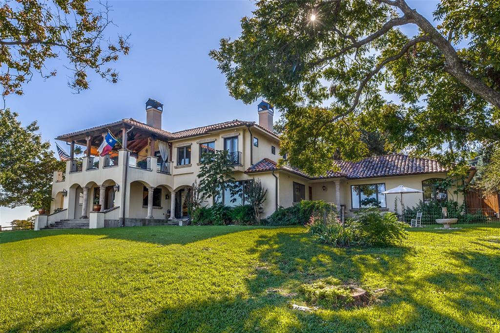 Experience the charm and sophistication of California living in this breathtaking Spanish-Eclectic home, perfectly positioned on an oversized lot with unparalleled views of White Rock Lake and its lush surrounding greenbelts. Custom-designed and built in 2004, this architectural masterpiece offers a rare opportunity to enjoy a lifestyle that combines the serenity of nature with the convenience of urban living. Step inside and be captivated by the abundant natural light that floods the home, highlighting its timeless design and picturesque views from nearly every room. The primary suite, located on the main floor, is a private retreat featuring dual bathrooms and two oversized walk-in closets. Upstairs, the home’s second-floor patio spans over 500 square feet, complete with a cozy fireplace and an exterior staircase, making it the perfect setting for entertaining while enjoying the breathtaking landscape. This home’s thoughtful design doesn’t stop at luxury; the oversized garage offers extra space for a small third car, a workshop, or additional storage. When it’s time to venture out, you’re just minutes from Downtown Dallas, Lakewood’s vibrant dining scene, and top-rated schools, ensuring convenience is never compromised. White Rock Lake is more than a view—it’s a way of life. Just steps away, you’ll find a haven for outdoor enthusiasts with 9 miles of running and biking trails, kayaking, paddleboarding, and sailing at the Corinthian Sailing Club. For those who appreciate the beauty of nature, the nearby Dallas Arboretum offers year-round botanical displays and peaceful gardens to explore. Whether you’re relocating or simply seeking a home that embodies lakeside elegance, this property offers the perfect blend of timeless architecture, stunning natural surroundings, and proximity to everything Dallas has to offer.
