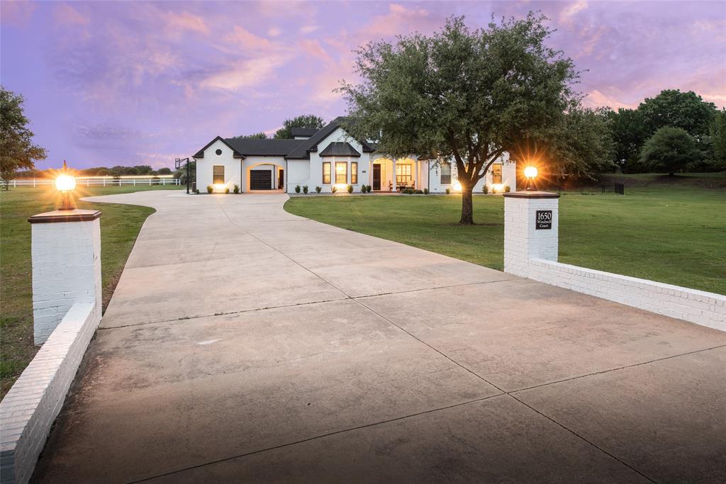 Nestled at the end of a quiet cul de sac in the highly sought after Lovejoy ISD, this stunning 1.5 story home offers exceptional design, comfort, and entertaining space throughout. The spacious kitchen is a chef's dream, featuring a gas cooktop, double ovens, an oversized island, abundant cabinetry, and extensive storage, all opening seamlessly to the inviting family room with a gas fireplace and expansive windows overlooking the covered patio and sparkling pool. The thoughtfully designed main home offers all bedrooms conveniently located on the first floor, with the primary suite set apart for added tranquility. The suite features a cozy sitting area with patio access, a luxurious ensuite bath, and a large walk in closet. Upstairs, the oversized game room provides the perfect space for entertaining, media, or recreation. A separate guest or pool house, connected by a covered patio, adds incredible flexibility with its spacious living area and full bath. Additional highlights include a 3 car garage, extended driveway parking, solid core doors, upgraded molding and trim, and quality craftsmanship throughout. This home presents an incredible opportunity in one of the area's most desirable communities.