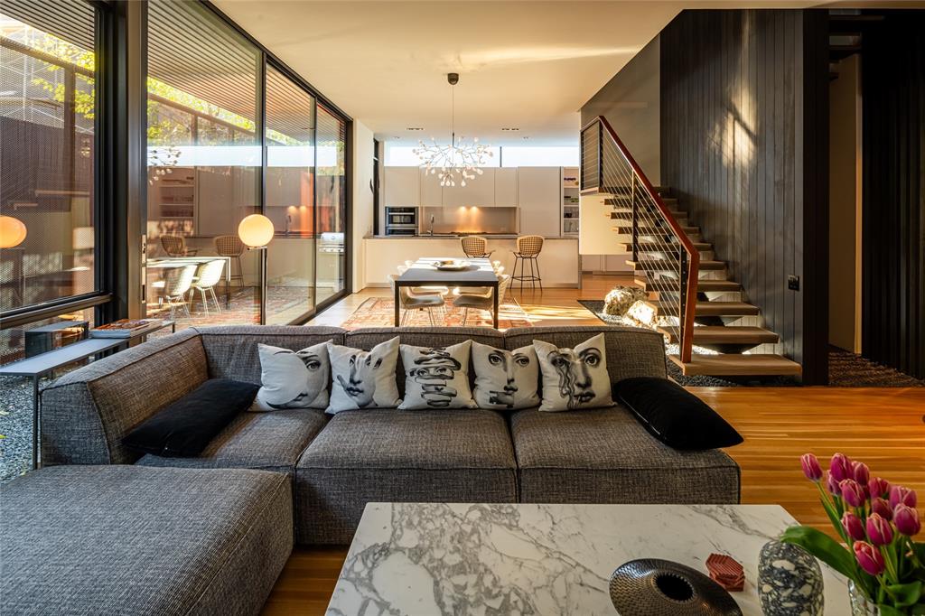 Designed by award-winning architect Cliff Welch and Rick Fontenot with Constructive in 2016, this single family attached home sits on a tree-lined property nestled in charming Northern Heights, just minutes from the Katy Trail and Knox Henderson. Inspired by Japanese architecture, Welch incorporated steel, stucco, and Douglas fir in the 4,117-sqft home to create a spacious, 3-story floorplan featuring 3 bedrooms, 4.1 bathrooms, 2 living areas, a 2-car garage, and elevator access to all levels. Find a family room that opens to the dining room and kitchen, which is outfitted with Miele appliances and Eggersmann cabinetry. A floating staircase takes you to the 2nd level, which includes 2 guest rooms with ensuite baths and a primary suite boasting a seating area, a spa-like bathroom, and a palatial walk-in closet. A spacious second living area on the third floor can also be used as a home office, fitness room, or guest suite and opens to large rooftop deck, wet bar and treetop views.