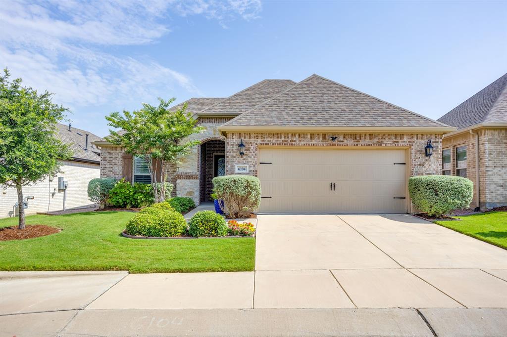 Enjoy the ease of move-in ready living in Ladera, a gated 55+ community designed for an active lifestyle with amenities including a clubhouse, community pool, pickleball courts, walking trails, dog park and more. Why build when this thoughtfully designed 2-bedroom, 2-bath home already offers the upgrades and outdoor living spaces buyers are looking for. Inside, the open floorplan features wood flooring throughout, plantation shutters, and a spacious living area centered around a corner fireplace. The kitchen offers a large island, granite countertops, tile backsplash, stainless steel appliances and plenty of room for entertaining. The private primary suite features dual sinks, a walk-in shower, and a large closet with direct access to the laundry room for added convenience. Enjoy morning coffee or evening gatherings from the screened patio and extended flagstone patio, creating outdoor spaces ready to enjoy from day one. Low maintenance living, established upgrades, and resort-style amenities make this an exceptional opportunity in one of Fort Worth’s premier active adult communities.