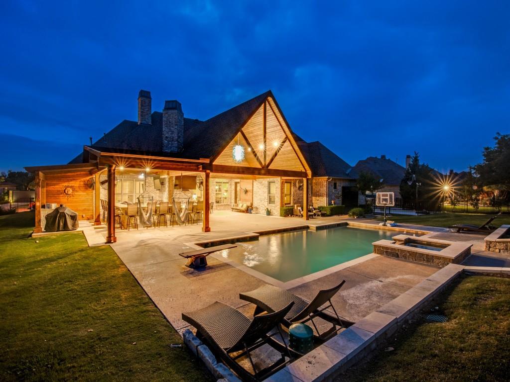 Wow, this house checks ALL of the boxes - welcome home to 125 Brentwood, located in the desirable Stoneleigh neighborhood in the lakeside community of Heath!   Experience elevated living with this thoughtfully designed 4 bedroom, 3 bath home offering 4,065 square feet of stylish comfort and exceptional entertaining spaces. Designed for both everyday living and memorable gatherings, the open floorplan seamlessly connects spacious living areas with impressive indoor and outdoor amenities. The main level features all bedrooms and bathrooms for added convenience, along with an office, wine room, expansive walk-in pantry, plantation shutters, and a private primary suite complete with a sitting area and an oversized primary closet with plenty of hanging space as well as shelving for folded items. Upstairs, a second living area provides flexible space for media, hobbies, or additional relaxation. Step outside to a resort-inspired backyard designed for year-round enjoyment. The outdoor living area features a wood-burning fireplace, three TVs, and a fully equipped outdoor kitchen with bar seating and two installed gas grills. A rectangular pool and spa are surrounded by generous patio space and a large grassy area, creating the perfect setting for entertaining or unwinding at home.  Additional highlights include a 4-car garage with wood doors and epoxy flooring. Conveniently located near Lake Ray Hubbard, this property offers the opportunity to enjoy the lifestyle and recreation of one of the area's most desirable lakeside communities.