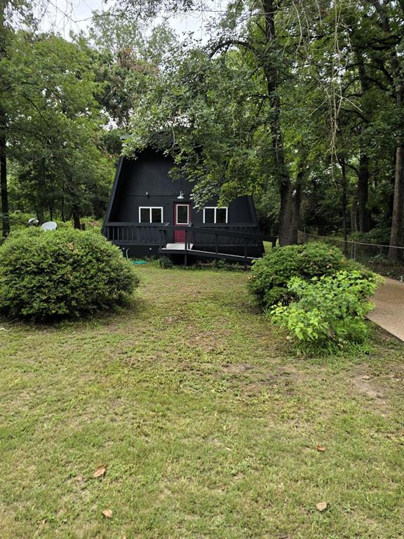 3 bedroom, 2 bath charmer nestled among the trees. Fresh paint and thoughtful updates create a warm and inviting atmosphere in this charming home. The main level features a spacious family room with hardwood flooring and a kitchen with durable linoleum flooring and a convenient pass-through bar for entertaining. Just beyond the kitchen, you'll find a versatile bonus room with the laundry area located nearby, offering additional space for a home office, hobby room, or playroom. The primary bedroom and full bath are located downstairs for added convenience. Upstairs two additional bedrooms and a bathroom with a shower provide comfortable accommodations for family or guests. Situated on a mostly wooded lot, the property offers a peaceful setting with both front and back yards gently sloping toward the road, creating a scenic backdrop and plenty of natural beauty to enjoy.