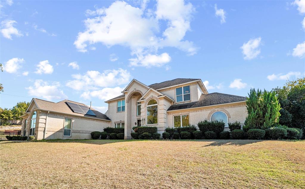 Major updates include a brand-new roof for added peace of mind and savings on homeowners insurance, plus sellers are replacing the lower retaining wall. Solar panels are paid in full and include a transferable warranty, offering long-term energy efficiency and value. Fresh interior paint and new carpet in four bedrooms make this home truly move-in ready. 

Welcome to your private retreat on just over an acre, offering 5 bedrooms, 4 baths, and nearly 3,500 square feet of comfortable, well maintained living space. Nestled in a peaceful neighborhood just off the beaten path, this property offers the perfect balance of privacy and convenience, only 20 minutes from downtown Fort Worth. Designed for both everyday living and entertaining, the spacious main living area flows effortlessly into the kitchen, dining, and breakfast spaces, all overlooking the backyard oasis complete with a heated pool, spa, and tranquil water feature. The main level features a dedicated office, a spacious primary suite with a sitting area, pool views, and direct patio access, along with an additional downstairs bedroom ideal for guests or multigenerational living. Upstairs, you'll find three additional bedrooms, two full baths, and a versatile media-game room perfect for movie nights, hobbies, or flexible living space.  Step outside and enjoy resort-style amenities including a covered patio, cabana, and a fully equipped guest house featuring built-ins, a full-size refrigerator, 2-burner cooktop, walk-in shower, dedicated water heater, and separate HVAC system—ideal for long-term guests, in-laws, a private studio, or home office.  This exceptional property combines comfort, flexibility, and outdoor enjoyment in a serene setting with room to breathe. Ask your agent for the full list of updates!