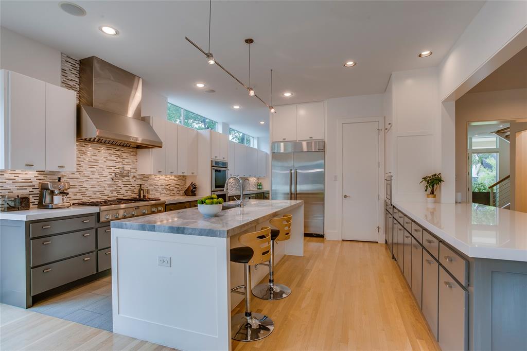 Nestled in the heart of Preston Hollow, this sophisticated contemporary home delivers the perfect balance of luxury, comfort, and everyday functionality. Built in 2014 with meticulous attention to detail, the home's sleek modern aesthetic is elevated by stunning architectural finishes and expansive picture windows that bathe every room in natural light. The chef's kitchen is a true showpiece, featuring dual islands, top-of-the-line Thermador appliances, a butler's pantry, and a second pantry with wine cellar potential , all opening seamlessly to the main living room with a dramatic wall of windows overlooking the private backyard. A second living area on the main floor currently serves as a media room and doubles effortlessly as a formal study or private office.The primary suite is a sanctuary unto itself, with spa-inspired bath finishes, a soaking tub, separate shower, dual vanities, and a custom-designed closet that rivals any boutique. Upstairs, four generously sized guest bedrooms each feature their own en suite bath and walk-in closet. A game room with wet bar and a bonus room round out the upper level, offering ample space for entertaining or unwinding. Outside, the backyard is a private retreat with a screened porch and outdoor kitchen, ideal for alfresco dining and entertaining. Thoughtful extras include abundant storage, a mudroom, and an oversized 3-car garage. Located in one of Dallas's most coveted neighborhoods, this home is a rare opportunity to experience refined modern living at its finest.