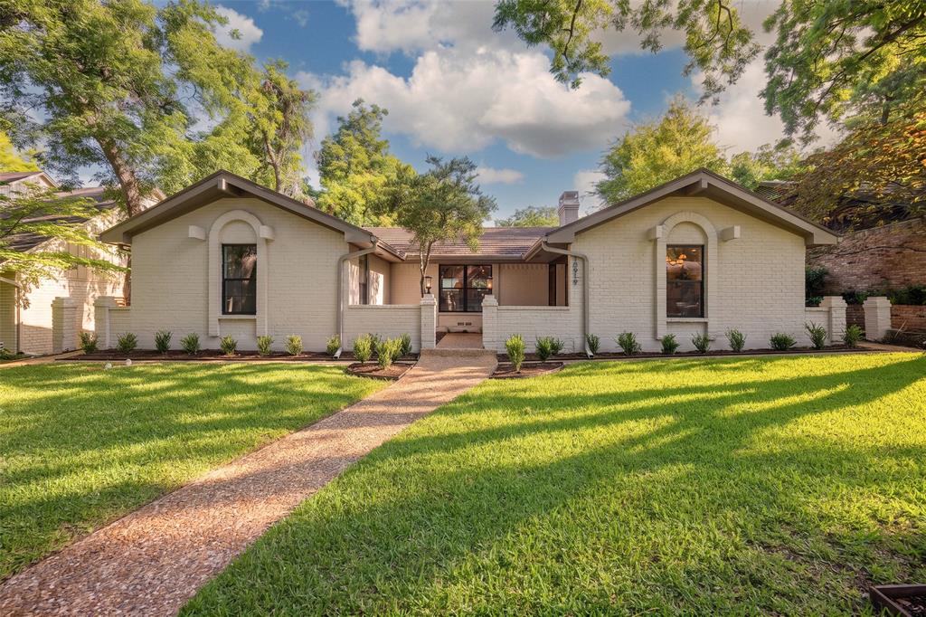 Set beneath the mature oak canopy Lochwood is known for, this 3-bedroom, 2.1-bath home thoughtfully reimagined by Maverick Design pairs elevated modern finishes with a functional, flexible layout. The 2,253-square-foot ranch-style residence opens to an entry strategically positioned between the living room, kitchen, and dining area, creating an effortless flow for everyday living and entertaining. At the front of the home, the inviting dining room is accented by a clean-lined modern chandelier.The show-stopping kitchen features a beautiful range hood, stainless steel appliances, quartz countertops, shaker cabinetry with elegant hardware, a gas range, and a built-in microwave for ease and convenience. A sizeable kitchen dining area with a bench seat also includes a full wall of built-in cabinetry, ideal for pantry use or additional storage. In the living room, a beautiful beamed vaulted ceiling is complemented by a floor-to-ceiling brick fireplace and graceful arched doorways. Three bedrooms are tucked along a hall adjacent to the living room. The large primary suite offers room for a sitting area and private access to the backyard. Its ensuite bath is appointed with flat shaker-style cabinetry, dual sinks, beautiful diamond checkerboard flooring, modern fluted-glass sconces, a large frameless walk-in shower with zellige-inspired tile, and a separate water closet. Wide-plank engineered wood floors, two-tone designer interior and exterior paint, recessed lighting, updated modern hardware, and refreshed light fixtures carry the home’s polished look throughout. Outside, the backyard creates an inviting retreat with a large covered stone patio. Ridgemeadow Drive offers the serenity of the lake area along with convenient proximity to White Rock Lake, Lochwood Park, Casa Linda retail, the Arboretum, and more.
