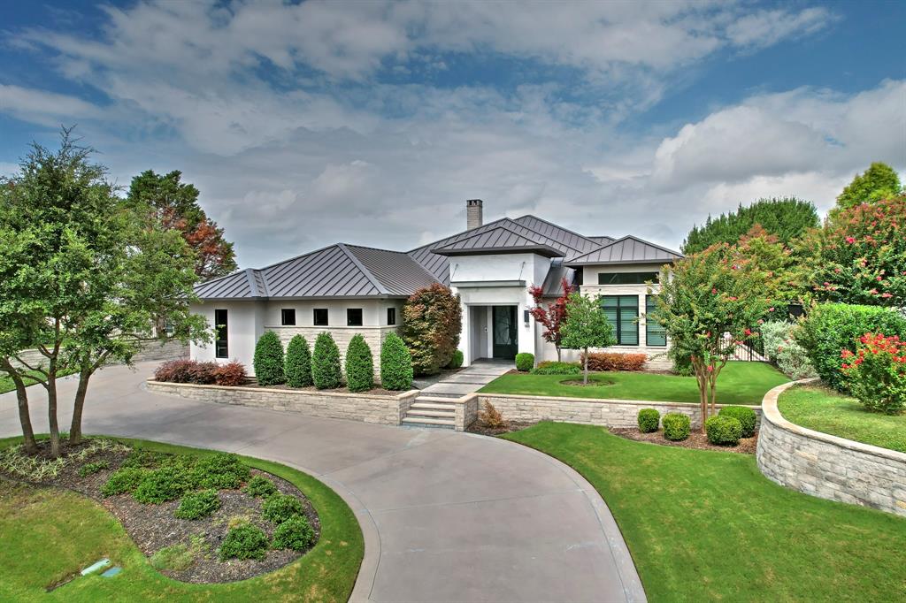 This custom-built contemporary masterpiece exudes refined elegance and modern sophistication. Located within the 24-hour gated and guarded golf course community of Mira Vista, this home is designed for elevated living. The four-bedroom residence welcomes you with light oak hardwood floors and a polished marble entryway. A dramatic Carrara marble fireplace wall anchors the great room, which flows seamlessly into an open-concept kitchen featuring sleek stone countertops, premium Thermador stainless steel appliances, including a 30-inch wine refrigerator, and a stylish U-shaped island with seating. The primary suite offers a cozy fireplace and serene pool views, complete with remote-controlled curtains. The primary bath features dual vanities, a separate shower and soaking tub, a custom closet, and a sleek exercise room leading to the patio and pool area. A retractable pocket door system transforms the outdoor living area into an enclosed oasis, ideal for year-round entertaining. The outdoor kitchen and extended stone patio are perfect for grilling. Additional highlights include a climate-controlled garage, foam insulation, and a dedicated staircase leading to a floored attic—perfect for storage.