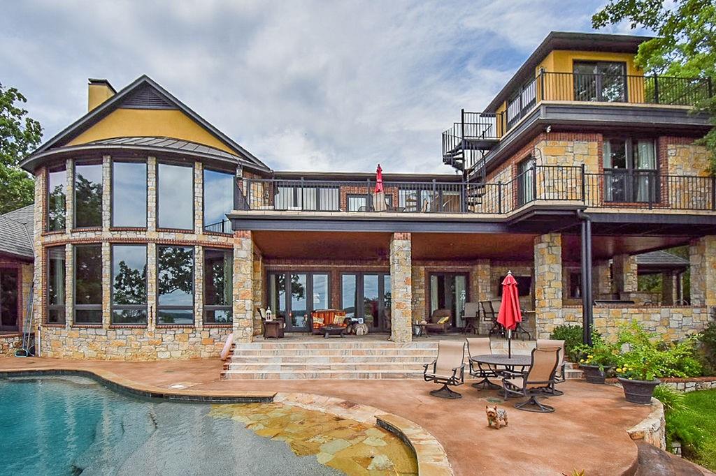 Waterfront home on almost 5 acres in Eagles Bluff community on Lake Palestine. This custom-built home with 6122 sq. ft. has 4 bedrooms, 4 baths, 3 car garage, a media-game room, living area with floor-to-ceiling windows on the lakeside. This home also includes an outdoor living-kitchen area with an infinity pool, slate tile patios & balconies, an outdoor fireplace area, approximately 900' of shoreline, a boathouse with a screened porch, an enclosed room, 2 electric lifts, and a sitting area. Incredible custom cabinetry throughout the spacious gourmet kitchen.  Heated marble floors in the primary bath. Custom blinds-drapes, granite countertops throughout, and an iron fence surround portions of the lawn.  Gas backup generator and separate storage garage shop. Enjoy the clubhouse & restaurant, well-maintained golf course, swimming pool, tennis courts, exercise facility, marina with boat slips for rent to members & much more! Various club membership options are available.