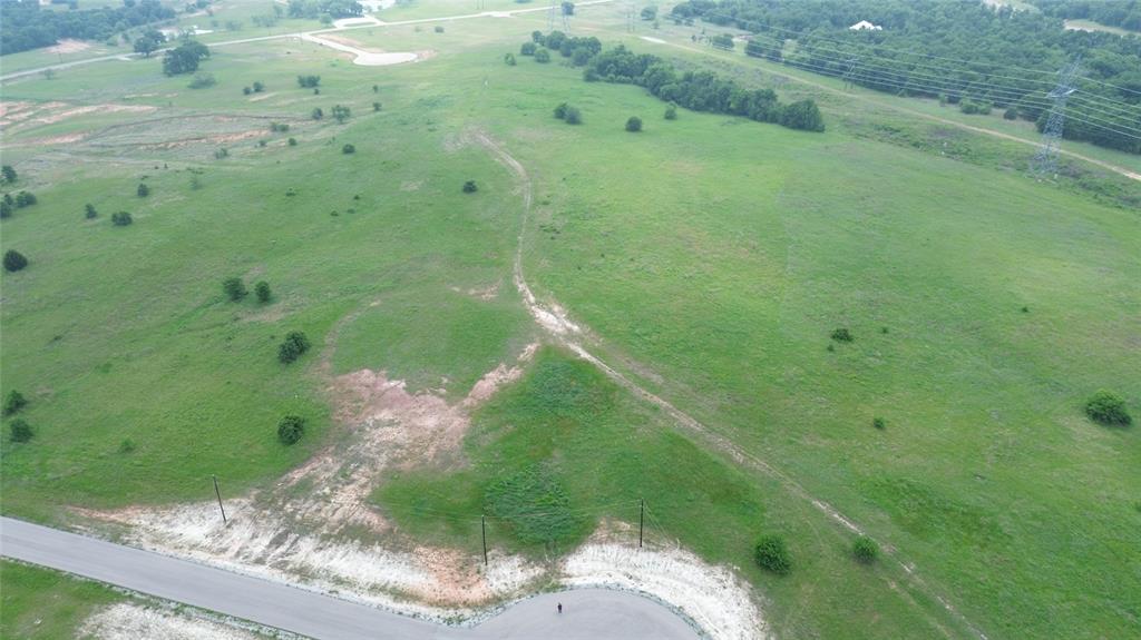This exceptional 5-acre parcel is situated just beyond the city limits of Alvord in The Ranches at Rolling Hills, offering impressive views of the surrounding landscape. The property features gently rolling slopes both at the front and rear, providing an elevated vantage point overlooking the lowlands of the ranches. Bardominiums are permitted, and the potential exists for panoramic vistas from a custom-built country residence. Conveniently located approximately 50 minutes from downtown Fort Worth, this lot presents an ideal opportunity to construct your dream home. High-speed fiber internet is available at the street. Additionally, owners have access to 250 acres of the scenic LBJ Grasslands, which offer a variety of recreational activities including fishing, hiking, and more.