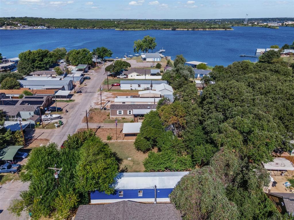 STEPS away from Lake Granbury! Remodeled 3-bedroom, 2-bath manufactured home on TWO adjoining lots in the Blue Water Shores community. This home features new carpet and flooring, fresh interior and exterior paint, updated cabinetry and countertops, newer fixtures, and a refreshed bathroom. The exterior HVAC unit is brand new, and additional updates include new skirting and overall exterior improvements throughout. A small storage building with electricity provides extra convenience and functionality on the property. The home sits only four houses down from the neighborhood boat dock, making lake access a breeze. Property includes both 6523 and 6525 Blue Water Court, offering versatile outdoor space for entertaining, gardening, or creating your own lakeside retreat. Blue Water Shores provides lake access, a relaxed community feel, and close proximity to Granbury’s historic downtown square with local dining, boutique shopping, and popular community events. Could be a wonderful full-time home, weekend getaway, or even an investment opportunity as a rental—location, location, location!