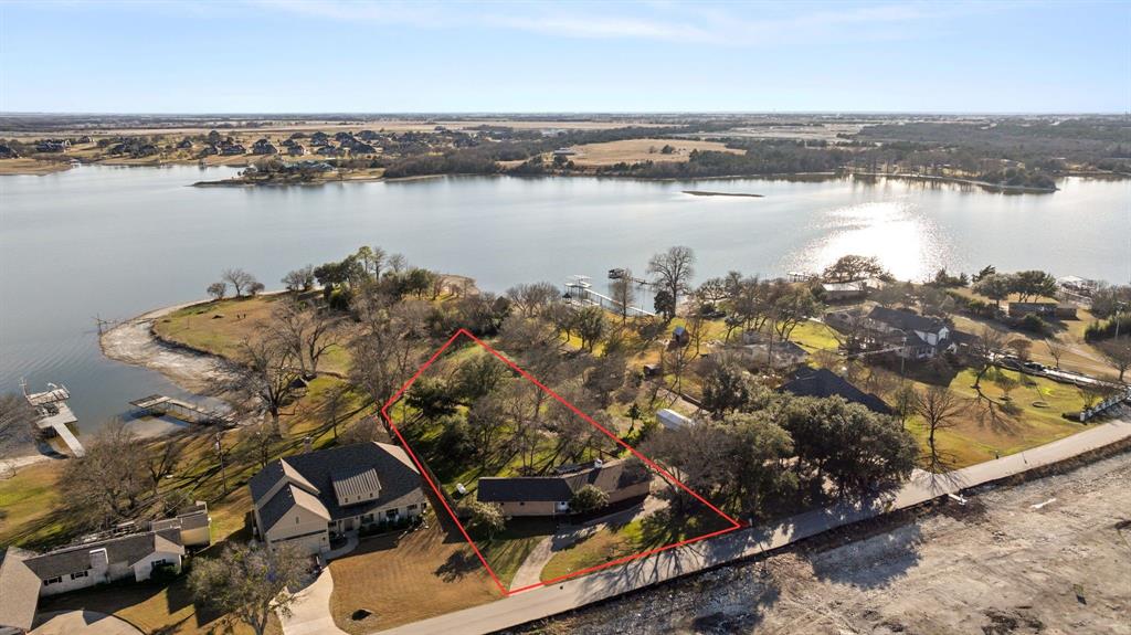 WATERFRONT HOME AVAILABLE AT A FANTASTIC PRICE!! RARE OPPORTUNITY ON THE SHORES OF LAKE WAXAHACHIE! HOMES DON'T COME AVAILABLE OFTEN ON THIS SIDE OF THE LAKE! Set on .520 acres, this 1957 built LAKEFRONT HOME offers timeless character and endless potential, perfect as a weekend escape, investment property, or full remodel into your dream house on the lake. With 2,016 square feet, the home features OVERSIZED LIVING ROOM WINDOWS THAT FRAME BREATHTAKING SUNSET VIEWS OVER THE WATER, filling the space with natural light. Step onto the covered back patio and unwind in a serene setting surrounded by MATURE TREES, NATIVE WILDFLOWERS, AND A THRIVING HABITAT FOR BIRDS AND WILDLIFE. THE PEACEFUL LANDSCAPE CREATES A PRIVATE, STORYBOOK FEEL RARELY FOUND THIS CLOSE TO TOWN. Whether you’re drawn to the charm of midcentury construction or the opportunity to reimagine a LAKESIDE RETREAT, THIS PROPERTY OFFERS A TRULY SPECIAL CANVAS IN ONE OF WAXAHACHIE’S MOST COVETED LOCATIONS.