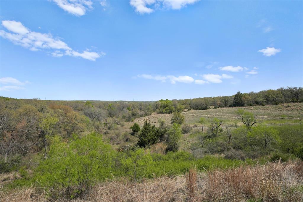 An extraordinary 153-acre equestrian ranch in the rolling countryside of Springtown, offering privacy, panoramic hilltop views, and turnkey functionality for the serious horse enthusiast or land investor. 
Set behind open pastures and framed by mature trees, this premier property features three scenic ponds, creating both natural beauty and practical water sources for livestock. The elevated terrain provides sweeping views across Wise County, delivering stunning sunrises and sunsets from multiple vantage points throughout the ranch.
Equestrian improvements are thoughtfully designed, highlighted by a 7-stall barn with ample space for tack, feed, and equipment. Multiple well-fenced turnouts allow for rotational grazing and proper horse management, making this an ideal setup for training, breeding, or simply enjoying a private equestrian lifestyle. The acreage offers room to expand with an arena, additional barns, or a custom estate home positioned perfectly on the hilltop to maximize the views.
For the savvy investor, this property presents an exceptional opportunity to subdivide into highly desirable 6–12 acre ranchettes. Preliminary feasibility work has already been completed, and a conceptual land plan is in place—providing a strong foundation for future development and maximizing the property’s potential.
Despite its peaceful setting, the ranch remains conveniently located just 25 minutes north of Weatherford and approximately one hour from Dallas-Fort Worth International Airport, allowing easy access to major travel, dining, and commerce while maintaining the tranquility of wide-open Texas land.
Whether envisioned as a private family ranch, equestrian training facility, weekend retreat, or long-term land investment, 2202 County Road 3657 represents a rare opportunity to own a substantial acreage property with water features, infrastructure, and breathtaking views in one of North Texas’ most desirable rural corridors.