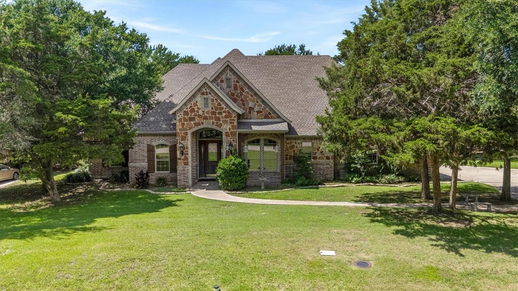 Discover a sanctuary of luxury and comfort in this stunning 4-bedroom, 3-bathroom residence nestled on a heavily treed half-acre lot in the sought-after Seis Lagos Community in Lovejoy ISD.   Designed with meticulous attention to detail, this custom home offers a harmonious blend of grandeur and warmth, perfect for those seeking an opulent lifestyle within a tranquil setting.  Stepping through the grand entrance, you are greeted by an expansive open floor plan that seamlessly connects the living spaces, all adorned with high-end finishes and abundant natural light. The gourmet kitchen is a chef's dream, boasting premium stainless-steel appliances, double ovens, 6 burner gas cooktop, custom cabinetry, center island, breakfast bar and sleek countertops, designed to inspire culinary creativity and provide an ideal setting for entertaining.  The elegantly appointed primary suite provides a peaceful retreat, featuring an expansive walk-in closet and a luxurious en-suite bathroom complete with dual vanities, a deep soaking tub, and a separate glass-enclosed shower. Each of the additional bedrooms is generously sized and offers ample closet space, with one well-appointed bathroom and one jack-jill bathroom ensuring comfort and privacy for all.  Beautiful home office with private French doors and built-ins. Outside, the property continues to impress with its breathtaking exterior features. An extended flagstone patio provides a perfect space for outdoor gatherings, set against the backdrop of a heavily treed lot that ensures both privacy and a connection to nature. The oversized 3-car garage offers ample storage for vehicles, walk up staircase to attic and more, rounding out this exquisite property that defines Texas luxury living. Covered front porch, covered patio and extended 48x20 flagstone patio. Plenty of room for a pool.   Seis Lagos is a lifestyle with a guarded entrance, community pools, clubhouse, playgrounds, courts and more.  This gem is ready for new owners.