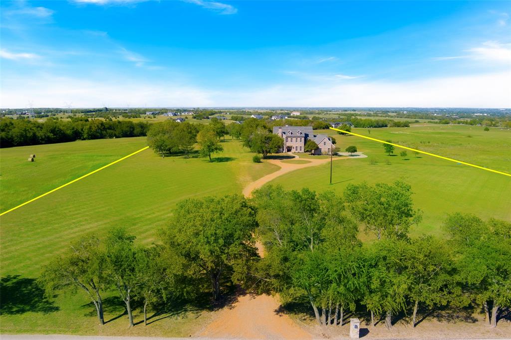 Experience breathtaking views from this stunning 12.6+ property, perched on one of the highest points in Collin County. Enjoy spectacular sunrises over fog-draped valleys and vibrant sunsets. Stunning German farmhouse-inspired custom home, completed in 2011, boasts 5 bedrooms and 4.5 baths, hand-scraped pine floors, reclaimed heart pine stairs, and stunning cedar beams. Highlights include a two-story living room with floor-to-ceiling windows, a custom stone fireplace, and a chef’s kitchen with honed granite countertops and a hand-hammered copper farmhouse sink. First floor media with charming wet bar. Two covered patios and room for a pool. Additional features include a three-car garage, and a custom 60 x 60 insulated barn with three horse stalls and space for RV storage. Additional acreage available.  Easy commute to DFW metroplex.