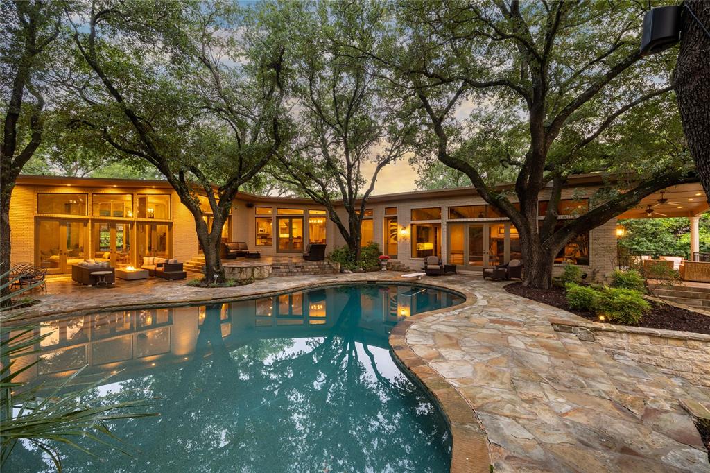 Set on a sprawling 1.08 acre, creek lot in the heart of picturesque Northwood Hills, this Mid-Century home boasts an open floor plan featuring clean lines, large open spaces, floor-to-ceiling windows, abundant natural light and seamless flow from indoors to out. Formal living areas graced with 16ft ceilings and sophisticated finishes include custom faux walls, travertine, five fireplaces, designer fixtures, premium countertops, Sub-Zero and Wolf appliances. The property features five bedrooms, four and a half baths. Owners retreat encompasses a separate wing with serene pool views, a sitting area, FP, wet bar, media room, marble bath, walk-in closets and flex space or gym. Gourmet kitchen opens to one of three living spaces complimented by a linear fireplace and atrium. Gallery hallway leads to a large gameroom, wet bar and wine cellar, surrounded by windows. French doors open to lush backyard complete with diving pool, sport court and patio.