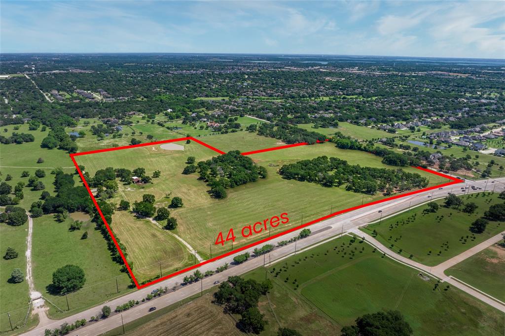 In the heart of Flower Mound lies a rare opportunity—a 44-acre rural oasis with a story rooted in vision and possibility. Decades ago, Dallas entrepreneur and philanthropist Sam Wilson discovered this stretch of land with easy access to DFW Airport and between Dallas and Ft. Worth. What others saw as country, he saw as promise. He shaped it into Shady Oaks, a weekend sanctuary for his family, and quietly expanded his holdings, acquiring surrounding acreage with an eye toward the future. Today, the final piece of that legacy is available for purchase —a sprawling pastureland at the corner of Cross Timbers Road and Lusk Lane, still echoing with the peace of country life, yet nestled within reach of established neighborhoods, top-rated schools, and thriving commercial hubs. Grazed by a content herd of Black Angus cattle and shaded by native hardwoods, this property offers more than beauty—it offers potential. Whether imagined as a private ranch or family compound, an investment to hold as Flower Mound continues to grow, or a blank canvas for something entirely new, this land invites visionary thinking. It’s rare to find a property that feels so removed yet sits so centrally, where the land itself speaks to history, family, and future possibilities. As one of only a few undeveloped parcels in the area, it’s not just a tract of land—it’s a chance to create something enduring. With deep roots and limitless future, this is where legacy and opportunity meet.