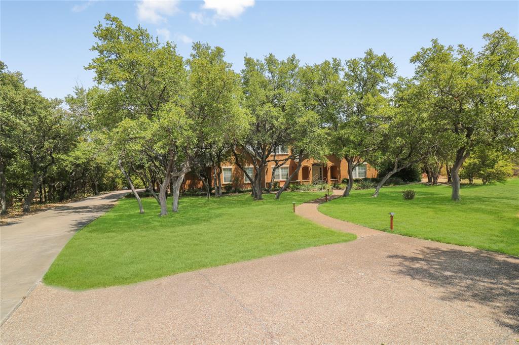 Enjoy peace and privacy in the gated community of River Creek in Aledo.  On a shady cul de sac, in a park like setting the home sits on a 2.3 acre plot.  Spacious and well planned the home boasts 3 living area and a kitchen to excite the family chef, with it's large prep space and many cabinets.  Pass through the butler's area to the elegant dining room.  Entertaining is sure to be breeze, as there are two liv areas on the first floor. One cld be an office or form liv.The home also includes two primary bedrooms with ensuite baths, One being on first level and the other upstairs. Your oasis awaits in the bkyd, featuring a sparking pool with a scenic back drop and expansive covered patio. Updated guest quarters, with views of the pool, include a bedroom, living room, kitchen and bath.  A generator is on premise in case of outages. Pking is no problem with a long driveway and 3 car garage with sink and wkshop.  Pool equipment is protected from the elements in another free standing garage.