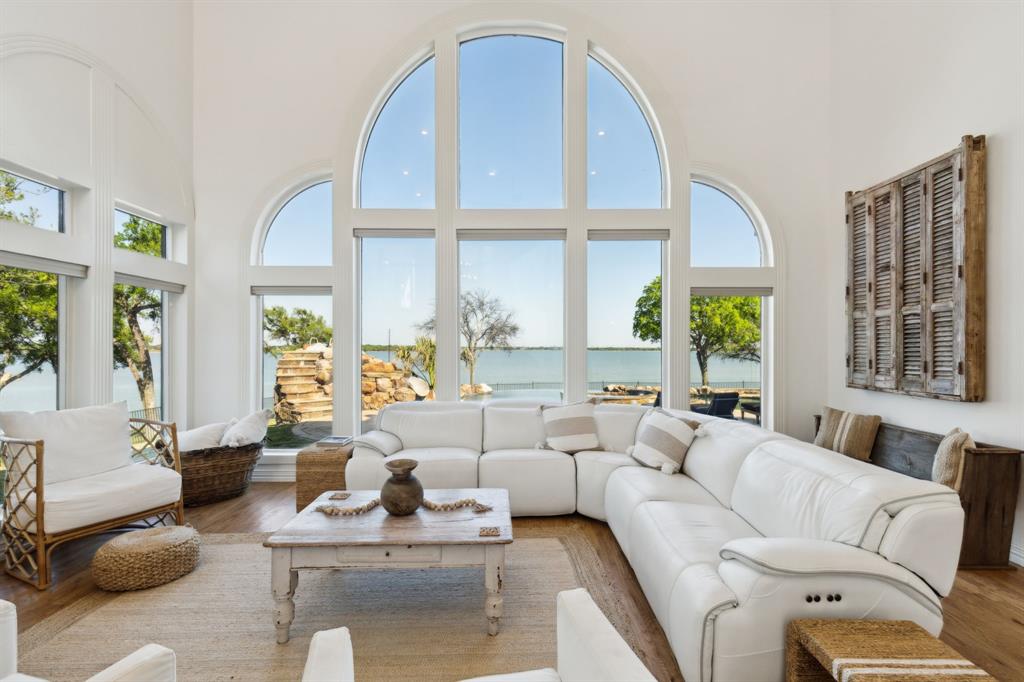 Tucked away on a secluded peninsula, this custom-built luxury home rests on two acres of prime lakefront property, offering an impressive 550 feet of shoreline. The setting is both private and panoramic, with sweeping lake views visible from nearly every room, including the spacious family room, kitchen, breakfast area and the primary suite. The home’s design blends elegance with functionality, featuring an attached 3-car garage, with one bay specifically designed to accommodate a boat and easy access via a circular driveway with additional parking. Inside, light pours into the open spaces, where three distinct living areas create endless options for relaxation and entertaining. The kitchen is the heart of the home-thoughtfully placed between the formal dining room and breakfast area to enhance the flow of gatherings big and small. The gourmet kitchen features quartz countertops, farmhouse sink, large center island with cooktop and breakfast bar, double ovens and a spacious walk-in pantry. The primary suite offers a luxurious retreat with a spa-inspired bathroom that includes an oversized walk-in shower, freestanding soaking tub, dual vanities and an expansive walk-in closet with abundant storage. Upstairs, two additional bedrooms accompany a cozy family room with a fireplace, a generous bonus room and a spacious covered balcony to soak in the view. Outside, the experience becomes truly resort-like! An 875-sq. foot enclosed cabana with central air, wood-burning fireplace, full kitchen including built-in BBQ, full bath and storage closet-making this the ultimate year-round hangout! A spectacular pool with a lakeside negative edge, grotto, water slide and hot tub anchors the backyard, complemented by a built-in firepit, outdoor shower, garden area, in-ground trampoline and putting green. This home is truly one-of-a-kind with breathtaking views all around, you are sure to make memories with friends and family that will last a lifetime!