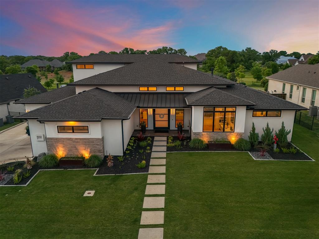 Experience luxury in this beautifully designed Bud Bartley custom home, perfectly positioned on a nearly half acre homesite backing to a private, lush greenbelt in Flower Mound’s prestigious Saddlewood community.  This 1.5 story modern masterpiece features a sprawling open floor plan designed for effortless entertaining. The chef’s kitchen serves as the heart of the home, boasting a massive island with leathered granite waterfall edges, premium cabinetry, and a walk-in pantry. The great room flows seamlessly to the family and dining areas, while a main level media and game room and dedicated office offer versatile spaces for work and play.  Retreat to the primary suite’s spa like oasis, complete with a freestanding soaking tub and a utility room conveniently connected. Each of the four spacious bedrooms features an ensuite bath and walk-in closet, including a private guest suite.  Outside, the backyard transformed into a private resort with a sparkling pool, spa, and an expansive covered patio overlooking scenic treed views. Built with full foam encapsulation for superior energy efficiency, this home also includes an oversized 3 car garage and a functional mudroom.  Showings begin April 17th.