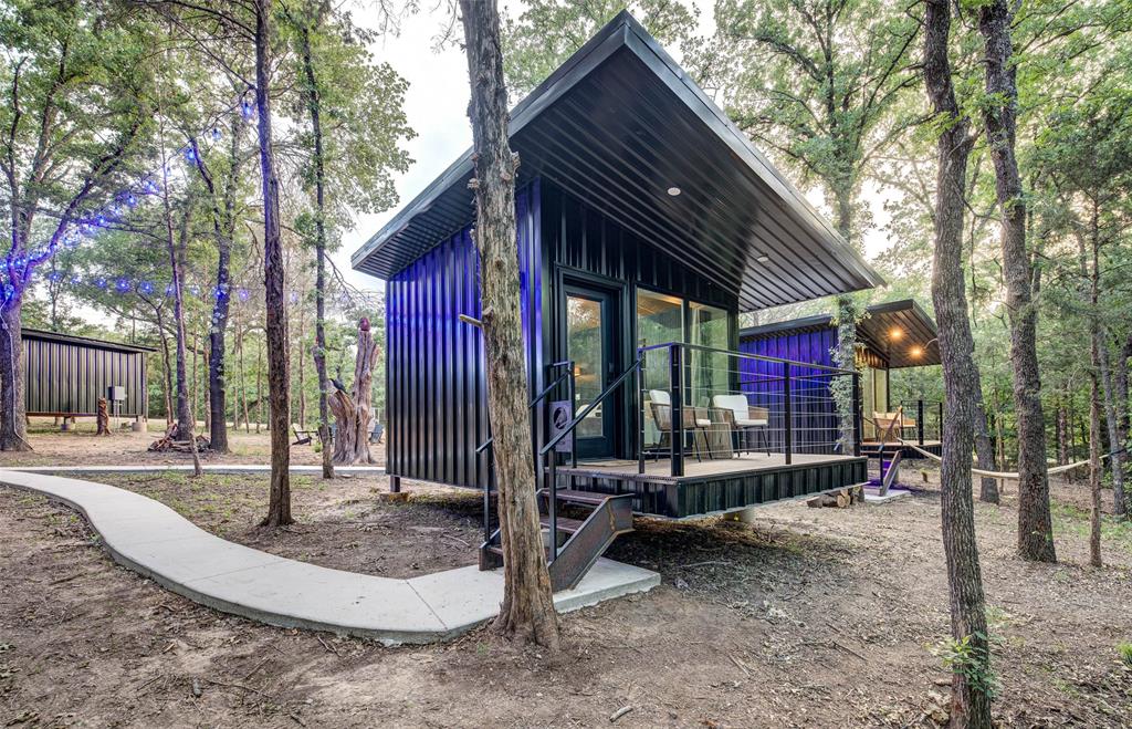 37± acres of opportunity in Alvord, Texas, where income potential meets intentional living. This one-of-a-kind property is already operating as a successful VRBO, offering a rare chance to step into an established, income-producing investment while still leaving room to grow and expand.
Tucked beneath a canopy of mature oak trees, the land itself is as valuable as the structures it holds. The property features four separate units, thoughtfully positioned to create both privacy and community, along with a centralized bath house equipped with four showers and commodes to comfortably support guests and future additions. Designed for experience as much as return, the grounds invite connection and relaxation. A pond, fire pit gathering area, hammocks swaying beneath the trees, and a dedicated pickleball court create a setting that keeps guests coming back. Every detail speaks to a property that has been curated for both enjoyment and revenue. With two water wells and a septic system already in place, the foundation for continued development is set. Whether you are looking to expand the current short-term rental footprint, create a private family retreat, or build out a multi-generational compound, this property offers the flexibility to bring that vision to life. For the investor, this is more than land, it is a proven income stream with scalability. For the visionary buyer, it is a place to gather, grow, and build something lasting.