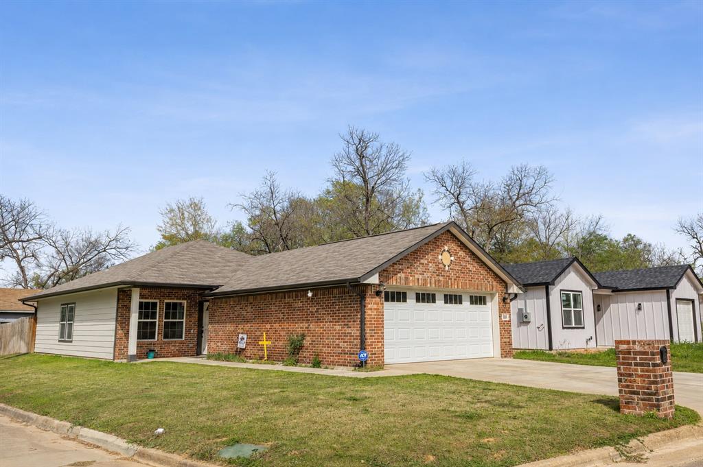 This newly constructed 4-bedroom, 2-bath home sits on a corner lot near downtown Sulphur Springs. Relax on the back patio or in the backyard hot tub, enclosed by a privacy fence. The yard is sodded with lush NorthBridge Bermuda grass, and a newly installed sprinkler system manages the whole property. Inside, enjoy luxury vinyl plank flooring and airy 9-foot ceilings in the living and dining areas. The kitchen and baths boast quartz countertops and a pantry. The private primary suite overlooks the backyard, featuring a tiled shower and dual walk-in closets. Three additional bedrooms offer versatility—ideal for a home office or gym. A welcoming front porch and full-size 2-car garage complete this inviting home.