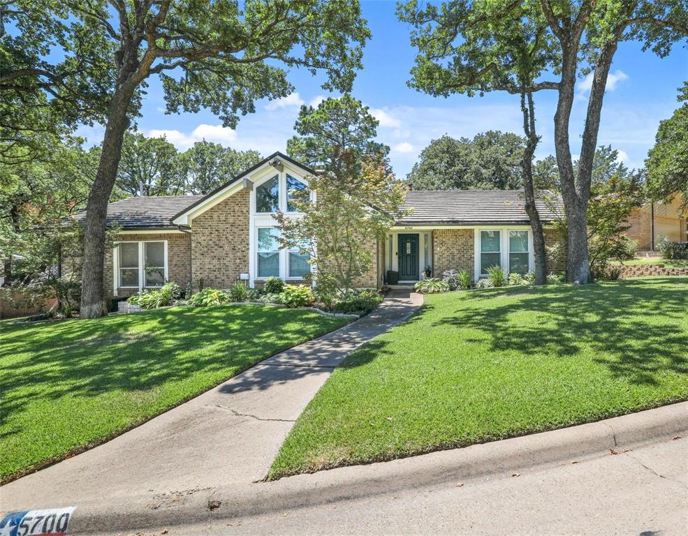 Welcome to this beautifully updated 3-bedroom, 2-bath home situated on an oversized, tree-shaded lot in a prime Arlington location, just minutes from major highways, shopping, dining, and entertainment. 
Step inside to an inviting open living area featuring soaring vaulted ceilings, striking wood beams, a cozy gas burning fireplace. Home has all large windows that fill the living areas with abundant natural light. The kitchen offers granite countertops, lots of cabinets for storage, newer appliances, recessed lighting, and updated flooring, while the spacious dining area & kitchen overlook the private backyard, perfect for everyday living and entertaining. Both bathrooms have been tastefully remodeled with elegant tile work and granite and marble countertops. Additional updates include the removal of all popcorn ceilings, newer energy efficient windows designed to help reduce utility costs, and a durable steel impact-resistant roof that provides long term savings and peace of mind. Step outside to a spacious, grassy backyard with plenty of room for gardening, outdoor entertaining, play, or simply relaxing under the mature trees. This house is a gem! Contact us to schedule a tour today!
