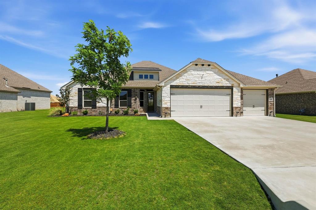 Step into effortless luxury in this beautifully designed 3-bedroom, 2.5-bath home with a private office, oversized utility room, and 3-car garage where modern comfort meets thoughtful functionality. From the moment you arrive, the striking curb appeal and upgraded landscaping create a warm, inviting first impression. Inside, the open-concept layout is filled with natural light and features soaring ceilings, designer finishes, and expansive living spaces perfect for both entertaining and everyday life. The chef-inspired kitchen serves as the heart of the home with an oversized island, custom cabinetry, stainless steel appliances, and seamless flow into the dining and living areas. Spray foam insulation adds year-round energy efficiency and comfort. The spacious primary suite offers a true retreat with spa-like finishes and generous storage while the secondary bedrooms are thoughtfully positioned for comfort and privacy. The oversized utility room adds even more functionality with abundant storage and extensive countertop space for folding and organization. Outside, the fully fenced backyard was designed for enjoying Texas evenings with a covered patio, outdoor living area, fire pit seating, and a separate covered patio space that could easily be converted into a future outdoor kitchen. There’s still ample room to add a private pool while also enjoying the amenities this gated Godley community offers, including a community pool, clubhouse, and scenic walking trails. Blending style, comfort, and functionality, this home delivers the kind of elevated everyday living buyers are actually searching for.