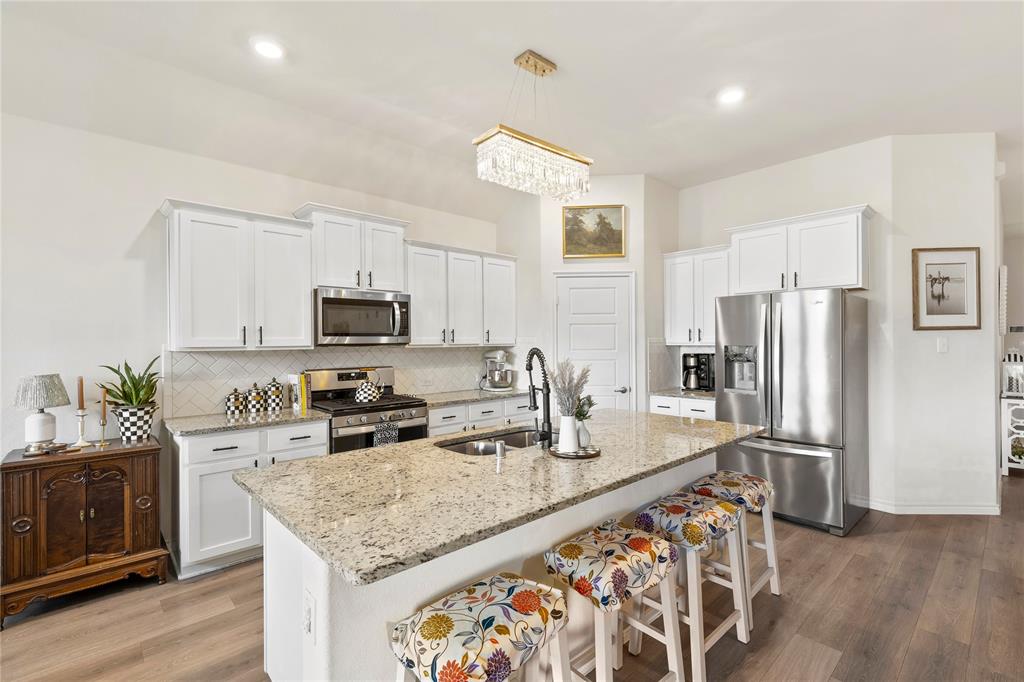 Welcome to 128 Whitetail Way…A HOME THAT TRULY FEELS LIKE A MODEL!!! From the moment you walk through the door, you’ll notice the difference. This highly sought after Bergamot floorplan features RARE 10 foot ceilings, A BUILDER UPGRADE NO LONGER OFFERED, creating a space that feels noticeably larger, brighter, and more open than anything else you’ve seen. This home has been meticulously maintained and beautifully styled, with updated light fixtures and upgraded cabinetry hardware in the kitchen that adds a clean, modern touch. The open concept layout is ideal for everyday living and entertaining, with a spacious living area that flows seamlessly into the kitchen and dining space. The kitchen features a gas cooktop, abundant cabinetry, and plenty of prep space, making it both functional and inviting. Offering 4 bedrooms and 2 full bathrooms, the layout provides flexibility for families, guests, or a home office, while the split bedroom design adds privacy and the primary suite serves as a quiet retreat. Additional highlights include a tankless hot water heater, 2 car garage, and a floorplan that maximizes every square foot. Step outside to a large covered patio overlooking the backyard, with plenty of room for outdoor seating, a TV, and grilling, perfect for entertaining. Located within walking distance to the brand new Kathy Kirkpatrick Elementary, this community offers a resort style pool, splash pad, scenic walking trails, ponds for catch and release fishing, a pool house, and playground, along with year round events and youth sports that create a true sense of community. Zoned to highly rated Caddo Mills ISD and offering quick access to I-30 and Hwy 66, you are just minutes from local dining, shopping, and all the charm Caddo Mills is known for. In a market full of similar options, this home stands out with a level of finish, layout, and presentation you simply won’t find in most resale or new construction.