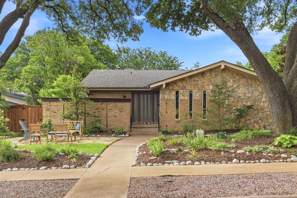 Tucked beneath a canopy of mature trees and thoughtfully redesigned throughout, this beautifully remodeled Mid Century Modern home offers a rare blend of architectural charm, functional living, and incredible outdoor spaces that make the home feel like a private treehouse retreat. The main level features an open-concept living, dining, and kitchen space filled with natural light and serene treetop views. The eat-in kitchen is both stylish and functional with quartz countertops, stainless steel appliances, and seamless flow for everyday living and entertaining. Three bedrooms are located on the main level, while the lower level offers a spacious family room, laundry room, and private fourth bedroom with ensuite bath—ideal for guests, teens, or a quiet work-from-home setup. Additional highlights include Elfa storage systems in five closets and the pantry, a home generator, and a two-car garage with epoxy flooring and ample storage. Completing the property is a guest quarters above the garage featuring a full kitchen and ensuite bath, perfect for visitors, extended stays, income potential, or additional flexible living space. Multiple outdoor living spaces create a peaceful, elevated feel throughout the property. Enjoy mornings surrounded by the trees from the upstairs deck with Trex slats and rails, unwind around the propane fire pit on the front stone patio, or host gatherings on the covered lower patio overlooking the lushly landscaped backyard filled with mature trees and native plants. The fully turfed backyard with sprinkler system and board-on-board privacy fence offers both beauty and low-maintenance living. Ideally located within walking distance to White Rock Lake, Hexter Elementary, and beloved neighborhood restaurants, this exceptional home captures the very best of Old Lake Highlands living.