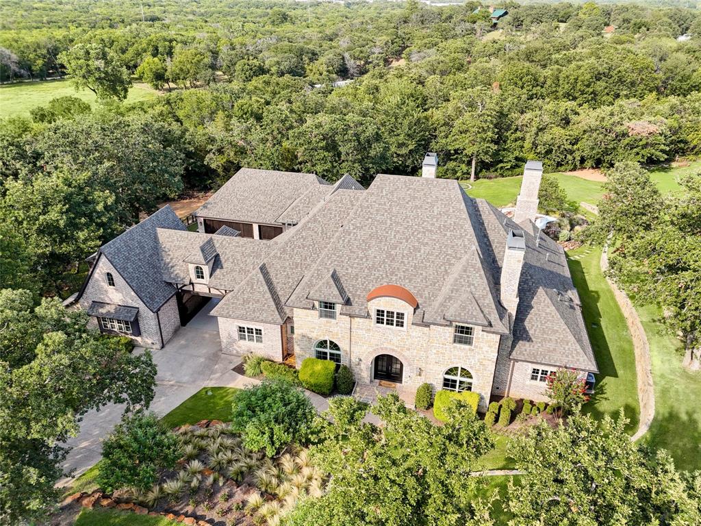 Welcome to your DREAM LUXURY ESTATE in Argyle, complete with an expansive outdoor living space perfect for entertaining, a resort-style pool, a relaxing spa, and professional-grade putting greens. The interior is a showcase of exquisite custom details, from the grand foyer with its sweeping staircase to the gourmet kitchen outfitted with top-of-the-line appliances and finishes to the hand-scraped hardwoods throughout. Unwind in your private home theatre, or explore the home's hidden gems with secret rooms designed for your ultimate privacy and security. Get your creative juices flowing as you work in the craft room! All 5 bedrooms offer ensuite baths and walk-in closets. Car enthusiasts will be delighted by the 4 ½-car garage, featuring pristine epoxy flooring and ample storage. View the stars at night from your incredible rooftop patio! Every corner of this magnificent estate exudes elegance and sophistication, offering an unparalleled lifestyle of luxury and comfort!