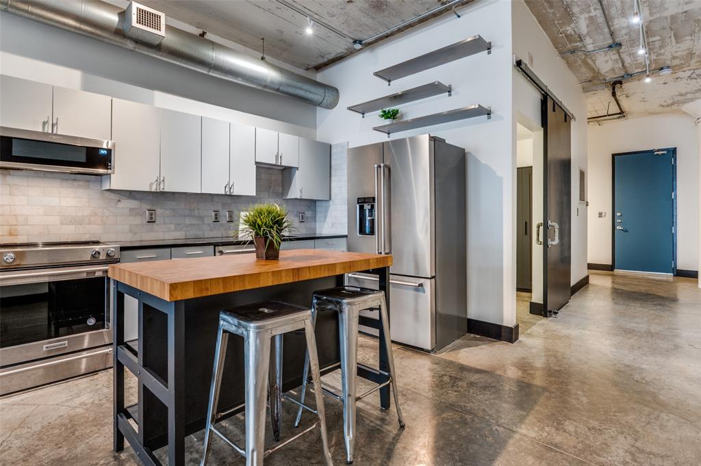 LOCK & LEAVE while you WALK, EAT & SHOP! Discover a rare blend of history and modern living in the heart of downtown Dallas Historic District with this exceptional loft featuring 9th floor views! Housed in a landmark building that once served as the former WFAA broadcasting station and Santa Fe Terminal, this residence offers timeless character paired with upscale amenities, including a rooftop POOL, fitness center, yoga studio, concierge service, GATED parking, & same-level storage. Located on the 9th floor, this stunning loft showcases soaring ceilings, exposed brick, and striking concrete floors that seamlessly combine historic charm with modern updates. Large windows flood the space with natural light, while thoughtful upgrades such as a Nest thermostat, custom remote-control shades, and designer lighting enhance both comfort and style. The beautifully renovated bathroom features a spacious walk-in shower with a stone floor and a sleek contemporary vanity. The kitchen is equally impressive, complete with stainless steel appliances, modern cabinetry, granite countertops, and a stylish stone backsplash. Refrigerator, washer, and dryer are all included, making this home truly move-in ready. * * Monthly HOA dues cover the pool, gym, parking, storage, PLUS water, trash, internet, concierge services, and on-site management for easy, low-maintenance living. * * Perfectly situated just one block from the vibrant AT&T Discovery District and minutes from Dallas Farmers Market and an array of popular dining and nightlife destinations, this one-of-a-kind loft offers an unbeatable urban lifestyle.