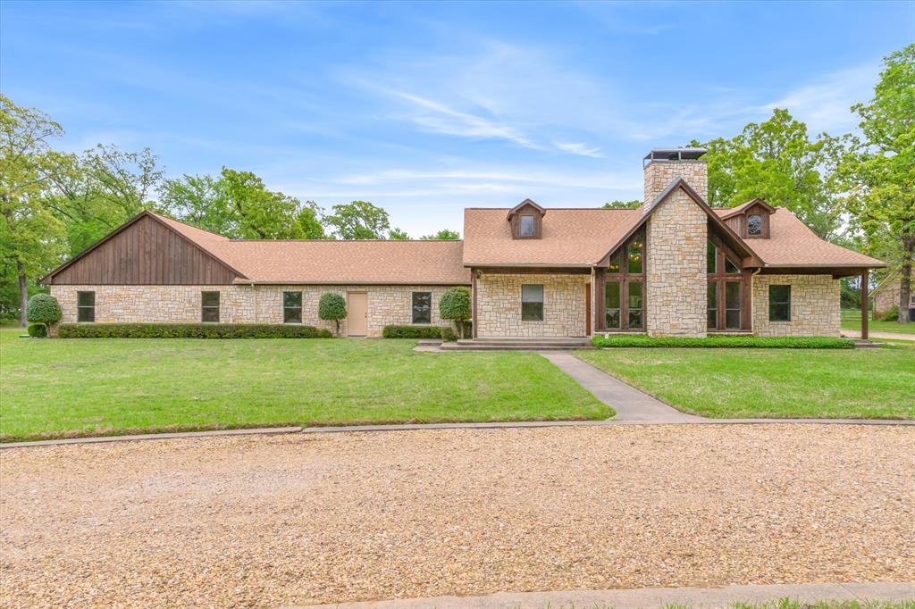 Stunning Custom Stone and Cedar Home with an attached apartment  perfect for generational living, rental, or VRBO.  Nestled on 2.37 manicured and treed acres in beautiful Lakewood Trails on a cul-de-sac street replete with mature trees and homes set back from the road, just a few miles from Hwys 19 and 243. A circle drive leads to this one-story 2408 sq. ft., 4 bed 3 bath ONE OWNER home. Enter a dramatic Great Room reminiscent of mountain homes with its vaulted wood ceiling and stone WBFP flanked by peaked windows. Open floor plan means your Dining, Breakfast Bar and Kitchen are open to the Great Room. Split bedrooms with the Primary large enough for a sitting area with ensuite bath. Other bedrooms offer large double closets and a full bath in the hall. Attached 3 car garage is perfect for all your vehicles or toys. On the far side of the garage enter the Guest Apartment with a huge open Living-Bedroom area, Kitchen and full Bath, perfect for family or rental with its own entrance and zoned HVAC. Both the Main Home and the Guest Apartment exit to covered porches for relaxation with views of lush lawns and trees. Ample drives access the back-entry garage as well as the Workshop and Greenhouse Structure. The Workshop is 35 x 20 and offers 2 rooms. One is insulated with a heating and cooling system (large enough to also service the 2nd room if desired). 2nd side is perfect for storage and lawn equipment. Roof replaced in 2024 and newer AC units replaced in 2023 (main home) and 2018 (Guest). Many updates (see list provided). Automatic water sprinklers, both City Water and Private Well. Alarm System and Security Cameras. Room for gardens and pets. This home was well designed, custom built and well maintained. It is hard to find established neighborhoods with the ambience and natural beauty found here. Your own slice of country with easy access to Canton schools, shopping and commute to Dallas or Tyler. Note: Total beds and bath include the Guest Apartment.