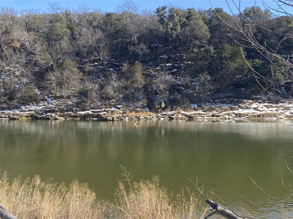 Located in the newer Premier community of Brazos Mountain Ranch. Stunning 6 acre River Front property with views of the surrounding hills. 1 acre is reserved for personal use (house, etc.). There is a well.  Electricity is available through United Cooperative Services which provides a generous credit toward bringing electricity to your new home. Septic will be needed. There is a 1 acre community lot with pavilions, fire pit, river access for family and guests to enjoy water activities and or fishing with current fishing license. The community hosts events and activities year round. This is truly a community that enjoys and helps each other as neighbors should. Build your dream home with all the conveniences of Mineral Wells night life close by, but country living steps away. Quiet nights and stars above await you and your family. 
Key Features: 
• Gated Community: Brazos Mountain Ranch is a gated community, providing a sense of security and exclusivity. 
• Scenic Views: Residents can enjoy pasture, trees, hills 
• AG Exemption: Low property taxes are available through the AG Exemption status via the Cattle Grazing Association. 
• Community Lot: A 5-acre community lot offers access to the Brazos River. 
• Location: The community is situated in Mineral Wells, Texas, providing a blend of rural living and access to local amenities. 
• Recreational Opportunities: The area offers various recreational activities like hiking, spas, mineral baths, and wellness centers, thanks to the city's history as a health resort. 
Brazos Mountain Ranch is a Gated Community. Build your own cabin, barndominium, or simply enjoy your land as you see fit. Minutes away from Possum Kingdom Lake. Palo Pinto County's New State Park featuring a visitors center, playscape, pavilion, equestrian, camping, fishing and more. Membership in a cattle grazing association is mandatory to insure that the very important AG-Exemption remains for all which saves thousands in property taxes.