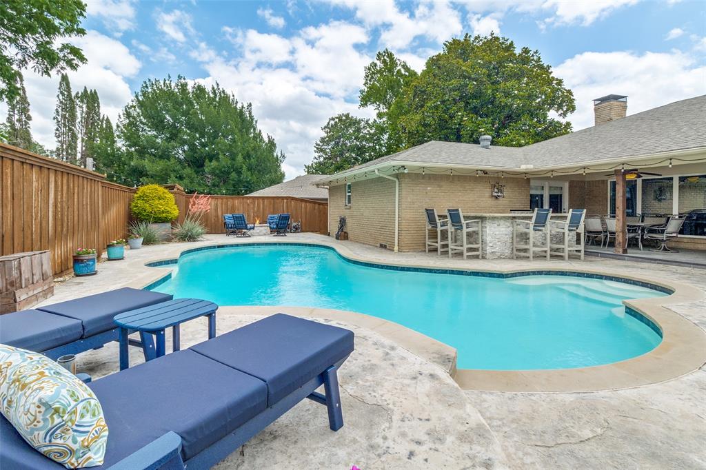 Charming and beautifully updated one-story home in the prestigious Prestonwood neighborhood of Dallas! Pre inspected and repairs done! Situated on nearly one-third of an acre, this 1967 gem offers the perfect blend of timeless character and modern upgrades with an incredible backyard oasis designed for entertaining. The fabulous outdoor living space features a large swimming pool, covered patio with TV viewing area, built-in grill, fire pit, and even a built-in putting green. An electric gate and oversized backyard create a private retreat ideal for relaxing or hosting family and friends. Inside, wood floors flow throughout the home. The spacious floor plan includes a private office with French doors, a large living area with stunning stacked stone gas log fireplace, custom built-in shelving, and views of the patio and pool. The beautifully remodeled kitchen opens to the living area and features quartz countertops, built-in stainless steel appliances, gas range with double ovens, wine bar, and wine fridge that will convey with an acceptable offer. The spacious primary suite offers direct access to the patio and pool along with a luxurious remodeled bath featuring dual sinks, quartz countertops, frameless glass shower with rain head, California Closet system, and separate his and hers closets. Two secondary bedrooms share an updated Jack and Jill bath with dual sinks and quartz countertops. The oversized fourth bedroom is currently used as a second office and media room offering endless possibilities as a game room, playroom, or flex space. Additional highlights include a three-car garage with built-ins and epoxy flooring, Richardson ISD schools, and convenient access to shopping, dining, Dallas North Tollway, and LBJ Freeway.