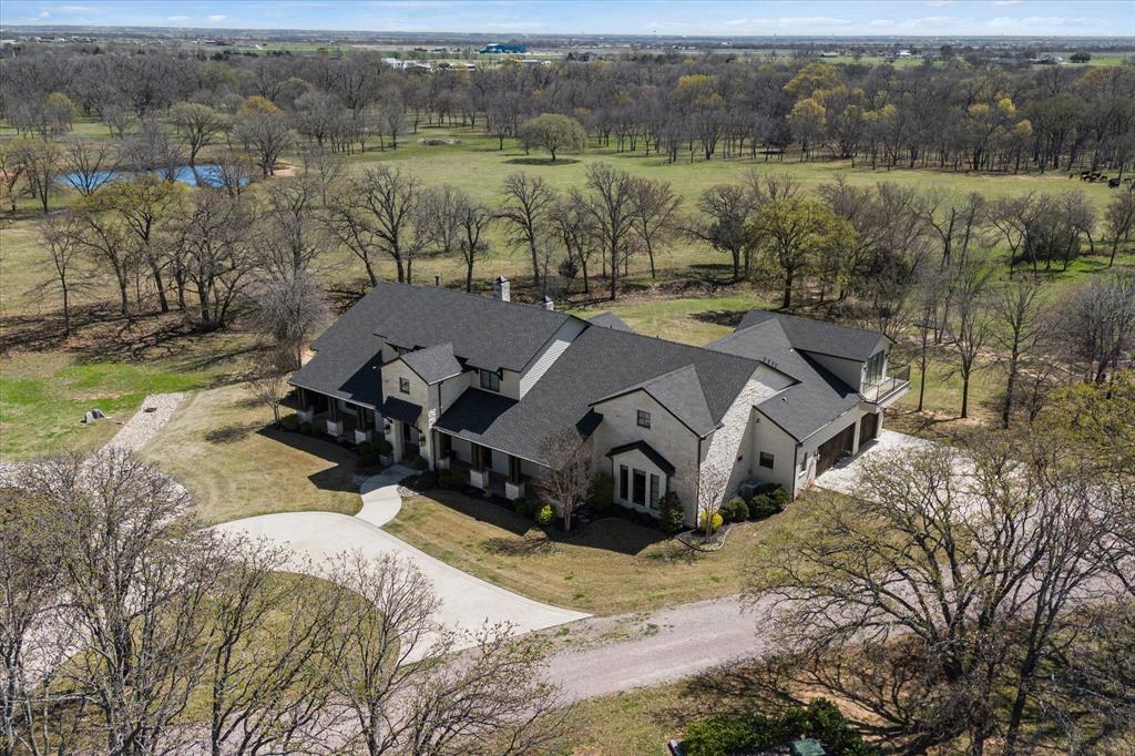 Experience the perfect blend of luxury, privacy, and ranch living on this breathtaking 68.88-acre estate in the heart of North Texas Horse Country. Naturally protected by scenic Pecan Creek, the property features rolling pastures, mature trees, and wide-open Texas skies—creating a peaceful retreat that feels worlds away while remaining just minutes from the North Dallas Tollway.

At the heart of the property sits an impressive custom-built ranch-style home offering over 5,000 square feet of thoughtfully designed living space. With 4 spacious bedrooms and 5 baths, the home showcases exceptional craftsmanship and an open-concept layout ideal for everyday living and entertaining.

The gourmet kitchen, complete with premium appliances and generous workspace, flows seamlessly into the expansive living area, anchored by a dramatic floor-to-ceiling stone fireplace. A wall of windows fills the space with natural light while framing breathtaking views of the pastures.
Designed for outdoor enjoyment, the breakfast room and main living areas open to a covered patio with a fully equipped outdoor kitchen and grill and a relaxing fire pit area—perfect for gatherings or quiet evenings under the Texas sky.
The ranch also offers functional amenities, including a cattle barn and ranch manager’s quarters, ideal for equestrian pursuits, livestock, or a fully operational ranch.
Whether you seek a luxury country estate, equestrian property, or a legacy ranch, this property offers the rare combination of privacy, comfort, and accessibility in one of North Texas’s most sought-after rural communities. Buyer and Buyers agent should independently verify the information provided.  This ensures accuracy and reliability in all transactions.