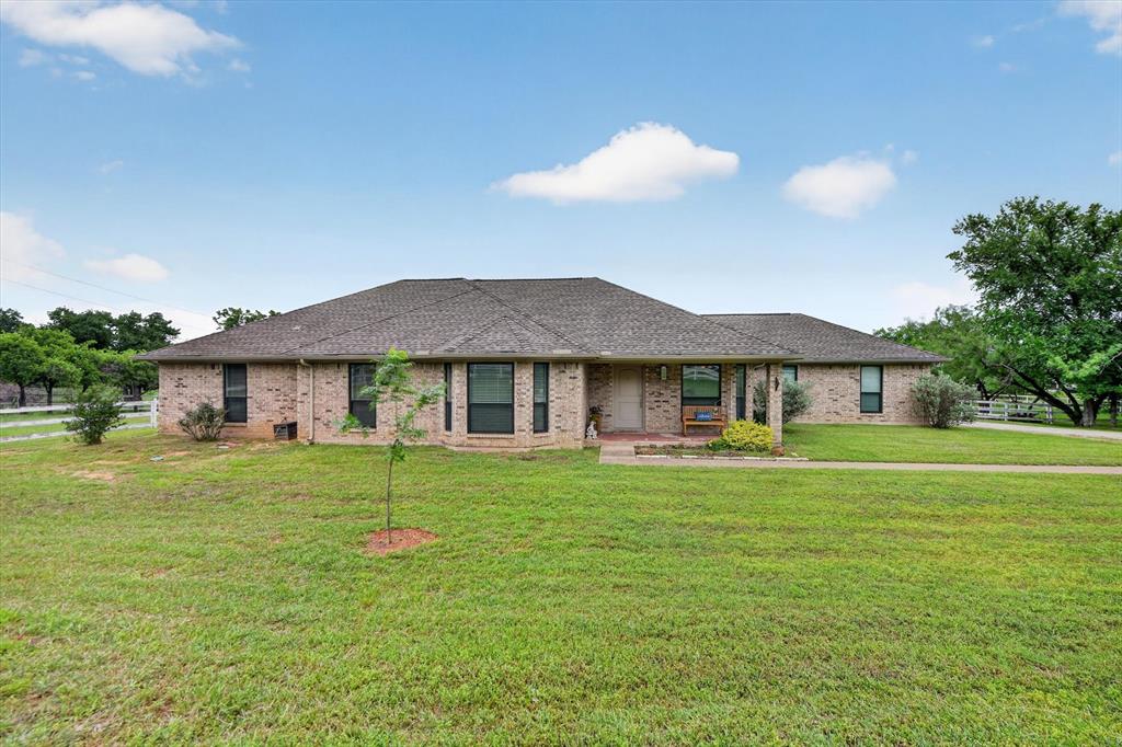 Breaking news! New roof is complete! This property is ready to enjoy! Imagine starting your morning with coffee on the screened porch, watching the sun rise over your back acreage, or ending the day there as the breeze settles in. Inside, the den feels warm and inviting, anchored by an electric fireplace with a heated blower for cozy winter evenings. A wall of new windows and glass doors blurs the line between indoors and out. A second living area with bay windows frames peaceful front-yard views. The breakfast area’s coffee and wine bar was made for gathering and entertaining. The spacious primary suite is a true retreat, complete with an updated en-suite and private porch access for quiet end-of-day escapes. Outside, this is more than a property, it’s a way of life. With a barn, workshop, and room for horses and animals, there’s space to live the Texas dream. The barn offers enclosed storage plus a separate staging area, while the workshop, with lighting and electrical, is ready for projects and passions. A run-in shed provides extended cover for vehicles, equipment, and your own forge. There’s a chicken coop ready for fresh eggs, raised garden beds awaiting the next season, and room to roam. Peaceful and private, yet just minutes from everyday conveniences, this is where life slows down and breathes a little easier. This is a place where every day feels a little more like a getaway. Bring the horses. Bring the animals. Bring the dream to life.
